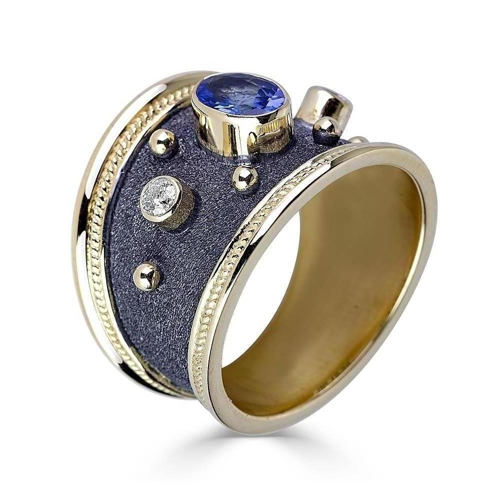 Anillo de oro amarillo macizo de 18 quilates del diseñador S.Georgios, decorado individualmente con granulado bizantino y un exclusivo aspecto aterciopelado en el fondo, acabado en rodio negro. Este magnífico anillo tiene 2 Diamantes Blancos talla