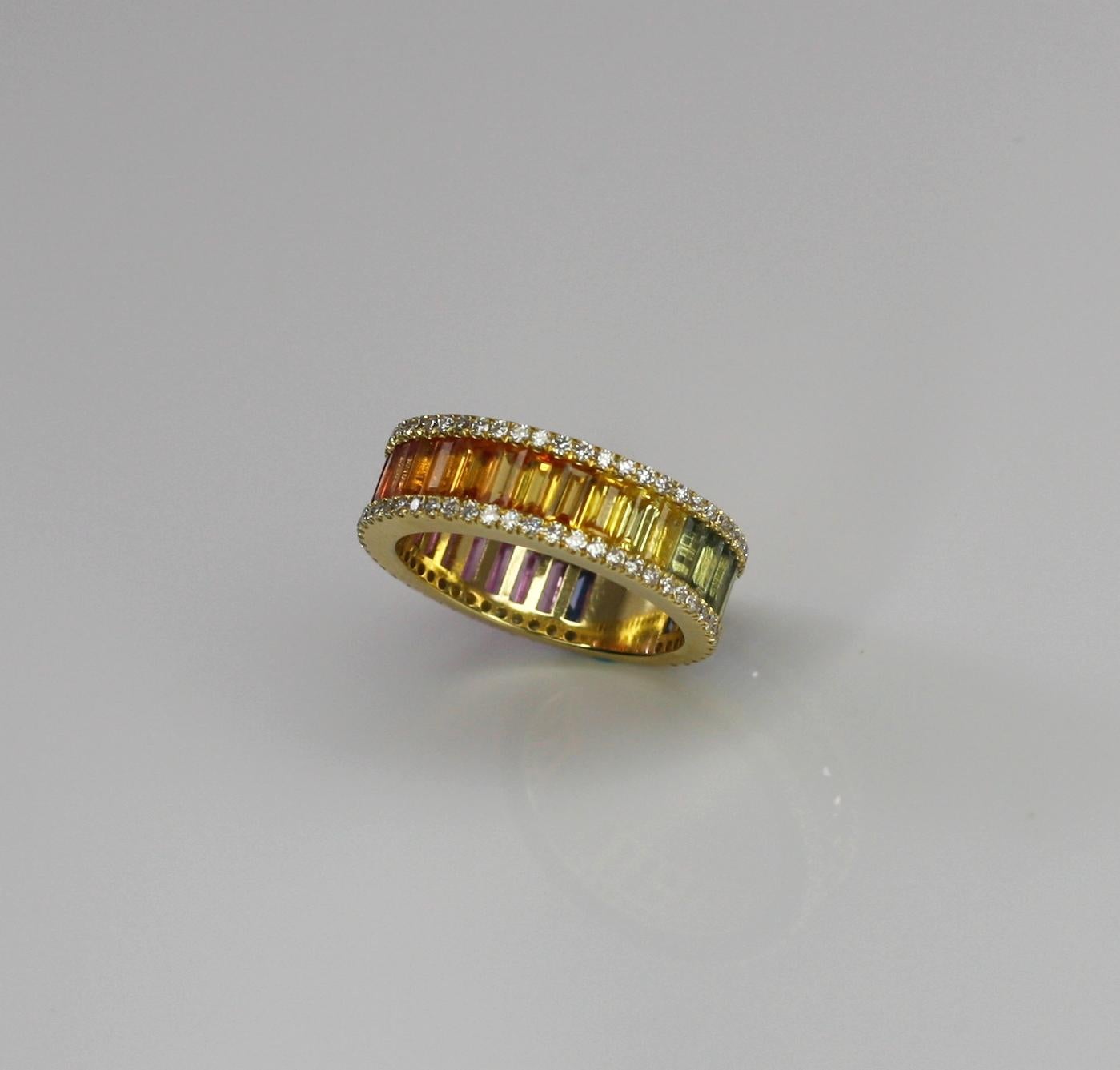 S.Georgios designer 18 Karat Yellow Gold Multicolor Eternity Band Ring with a row of an invisible set Rainbow color baguette Cut Sapphires of the total weight of 4.60 Carat and 0.60 Carat Brilliant Cut White Diamonds on the sides. 
This gorgeous