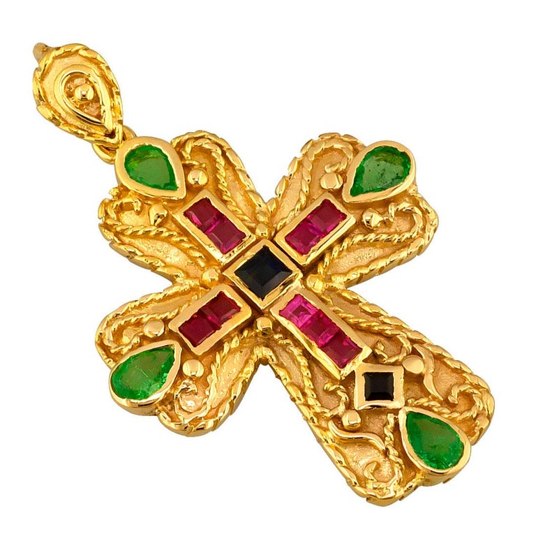Presenting S.Georgios designer byzantine style cross pendant enhancer is handmade from solid 18 Karat Yellow Gold and features 9 Princess cut Rubies, 2 Princess cut Sapphires, and 4 pear shape Emeralds with a total weight of 1.30 Carat. This