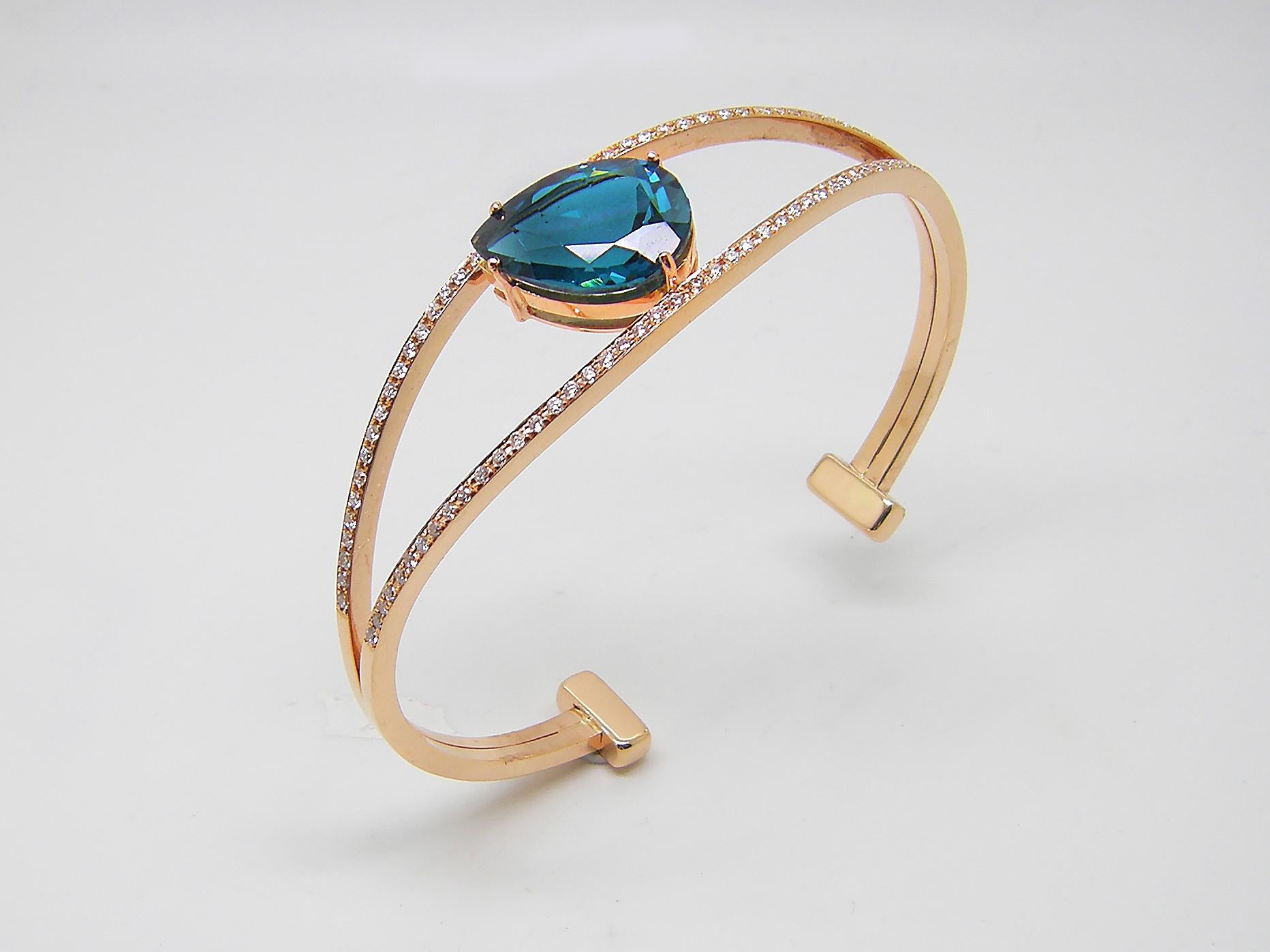 This S.Georgios designer bangle cuff bracelet is custom made of Rose gold 18 karats. The gorgeous cuff has brilliant cut white diamonds total weight of 0.80 Carat and a London Blue Topaz total weight of 10.20 Carat and is all set microscopically.
We