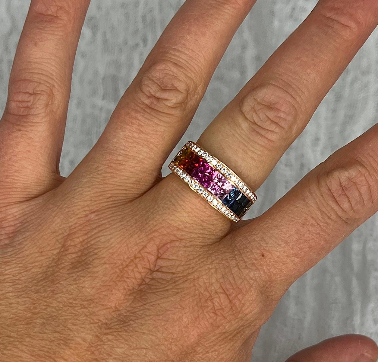 S.Georgios designer presents this gorgeous 18 Karat Rose Gold Band Ring with two rows of invisible set Rainbow color Princess Cut natural Sapphires with a total weight of 2.82 Carats and 0.39 Carat Brilliant Cut White Diamonds on the sides.
This