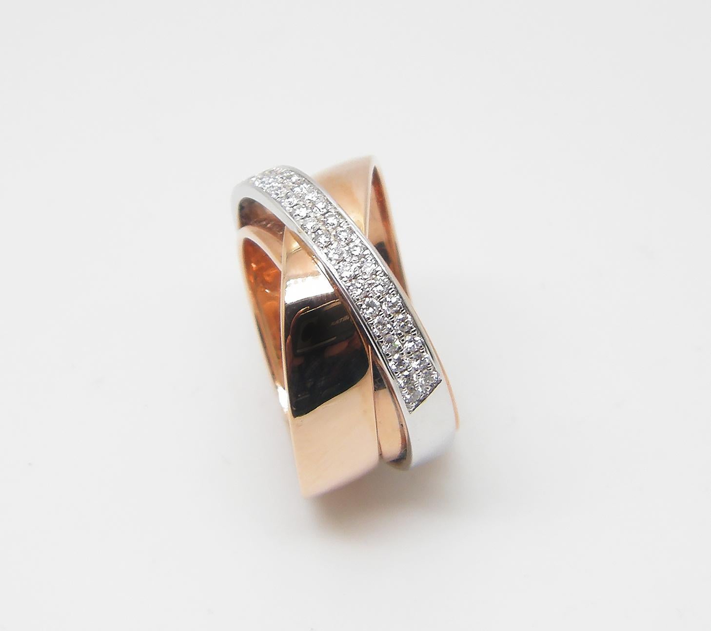 S.Georgios designer 18 Karat rose gold and white gold two-tone diamond band ring is all handmade in a unique design of three rings combined together. The gorgeous band features brilliant cut white diamonds total weight of 0.32 Carat in a microscopic