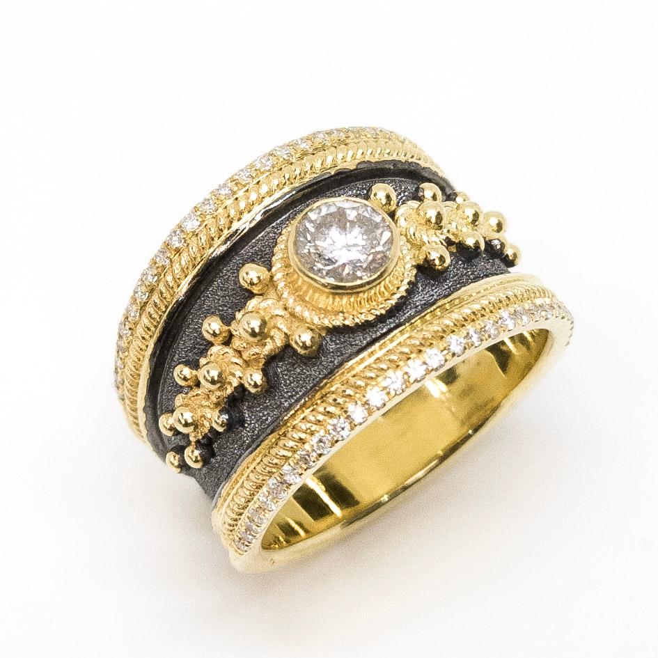 This gorgeous S.Georgios designer ring is handmade from solid 18 Karat Yellow Gold and is decorated with granulation details and a velvet background in Byzantine style finished with Black Rhodium and would make a unique engagement ring. The ring