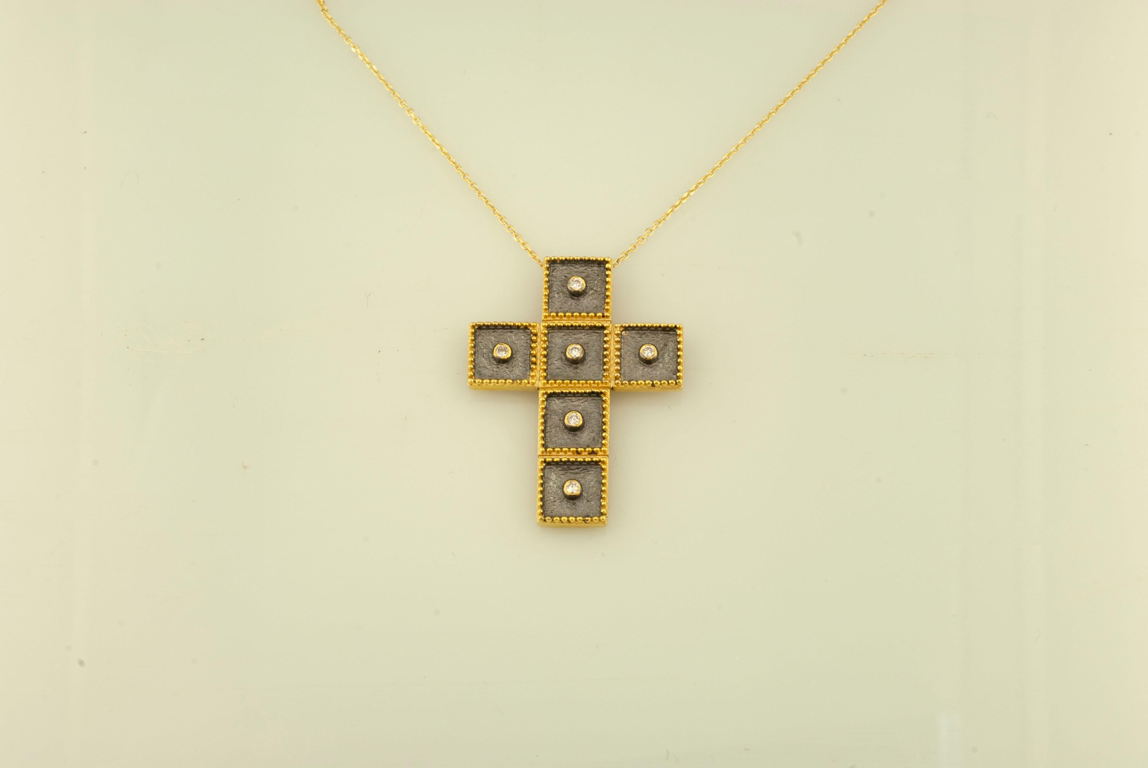 Questa collana con ciondolo a croce in oro giallo 18 carati e rodio nero e la catena di S.Georgios sono realizzate a mano con decorazioni microscopiche in stile bizantino e uno sfondo di velluto unico. Questa splendida croce è rifinita con un fondo