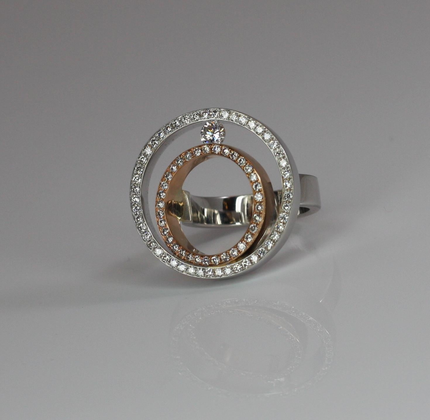 S.Georgios designer White and Rose Gold 18 Karat Ring features two gorgeous round surfaces with diamonds. This beautiful ring is made from three solid gold pieces connected and features two bezels of pure white brilliant-cut diamonds total weight of