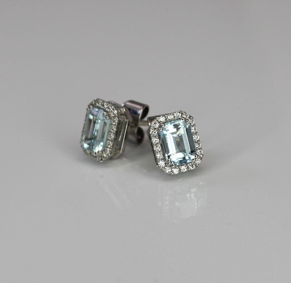 These S.Georgios square earrings are 18 Karat white gold and all handmade. The stunning pair is decorated with Brilliant cut Diamonds, a total weight of 0.26 Carat and Emerald cut Aquamarines in the center a total weight of 1.80 Carat. 
These