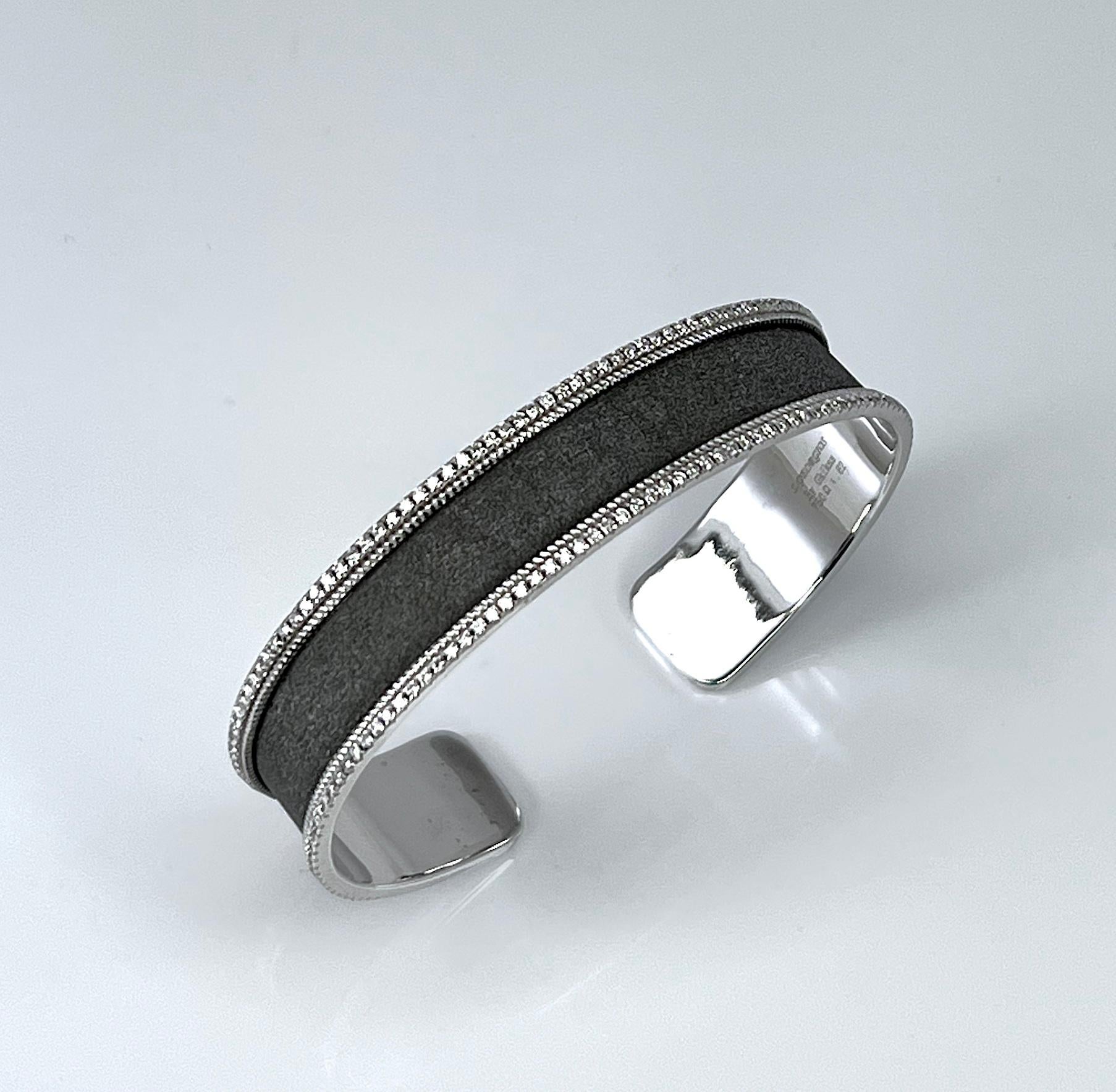 S.Georgios designer bangle bracelet is handmade from 18 Karat white gold. It is finished in Byzantine style with a unique velvet texture on the background and an overlay of Black Rhodium. The bracelet features two lines of brilliant-cut white
