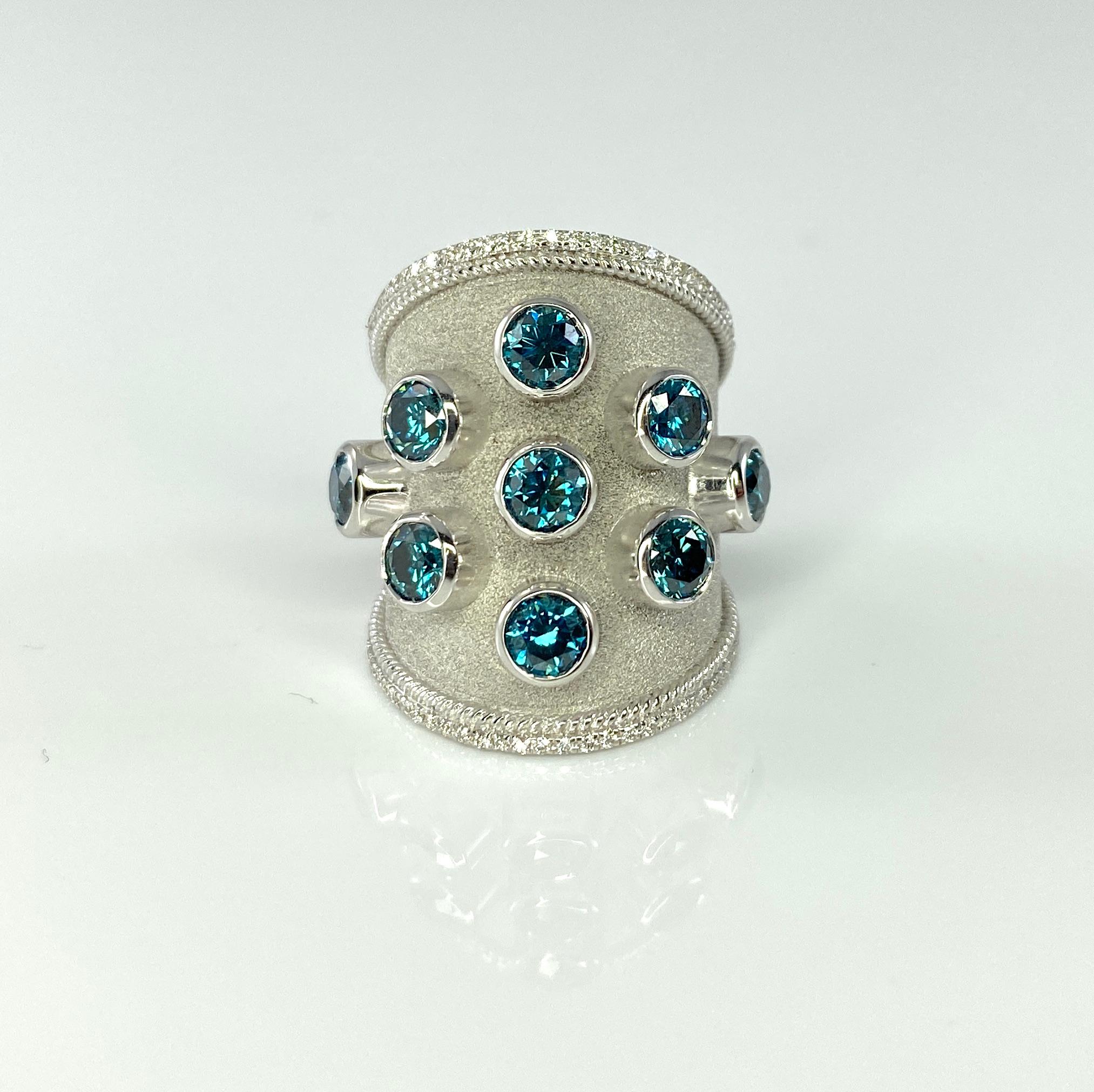 S.Georgios designer 18 Karat White Gold Thick Band Ring is handmade with Byzantine workmanship and a gorgeous velvet background done under a microscope. The beautiful ring features 9 Brilliant cut Blue Diamonds total weight of 2.68 Carats and