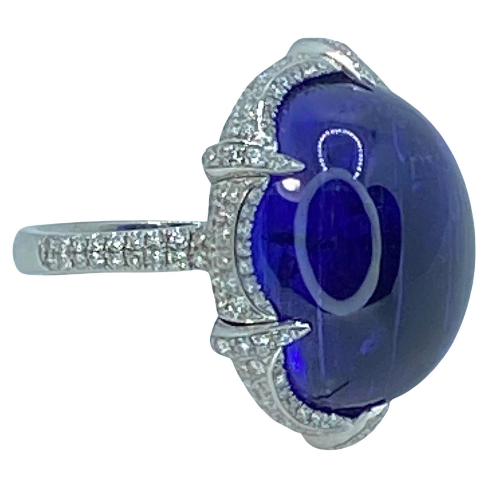Der Solitär-Cabochon-Ring von S.Georgios ist ein handgefertigter Ring aus 18 Karat Weißgold. Dieser wunderschöne, einzigartige Ring enthält einen Solitär mit einem natürlichen Tansanit im Cabochon-Schliff mit einem Gewicht von 37,7 Karat und