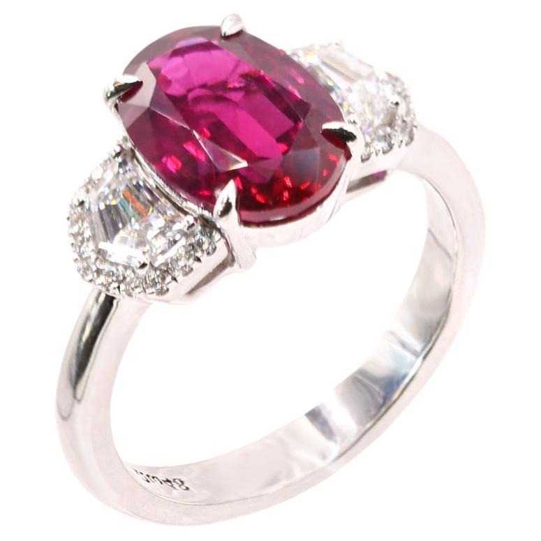 S.Georgios designer presents an exquisite 18K White Gold Ring featuring a Natural deep reddish-purple oval-cut Ruby, weighing 4 Carats at its center. Flanked by two Cadillac Cut Diamonds with a total weight of 0.88 carats, this stunning piece