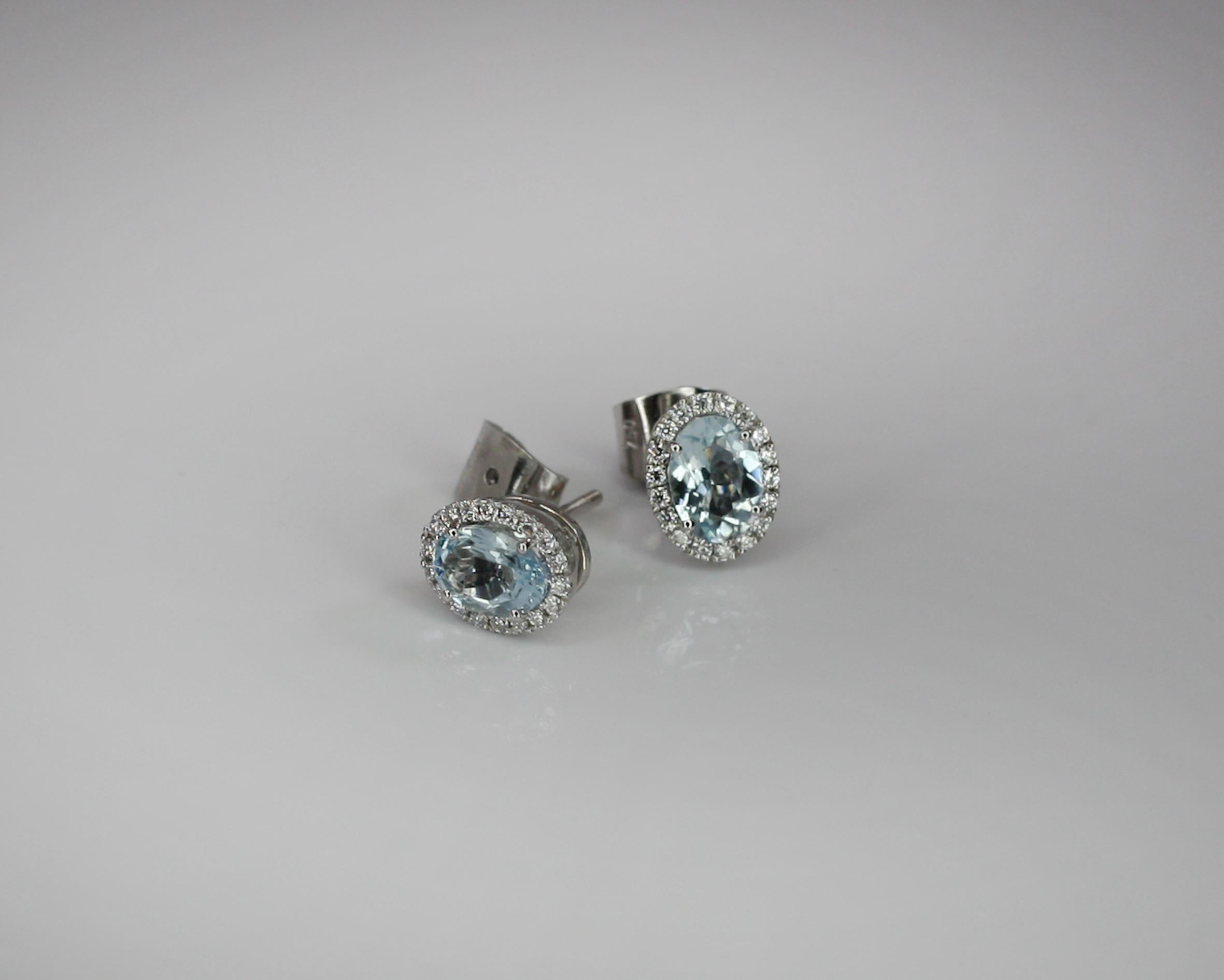 These S.Georgios designer stud earrings are hand made from 18 Karat White Gold to create a classic and elegant look. These beautiful earrings feature 2 oval shape natural Aquamarines total weight 1.30 Carat, surrounded by 36 natural brilliant cut