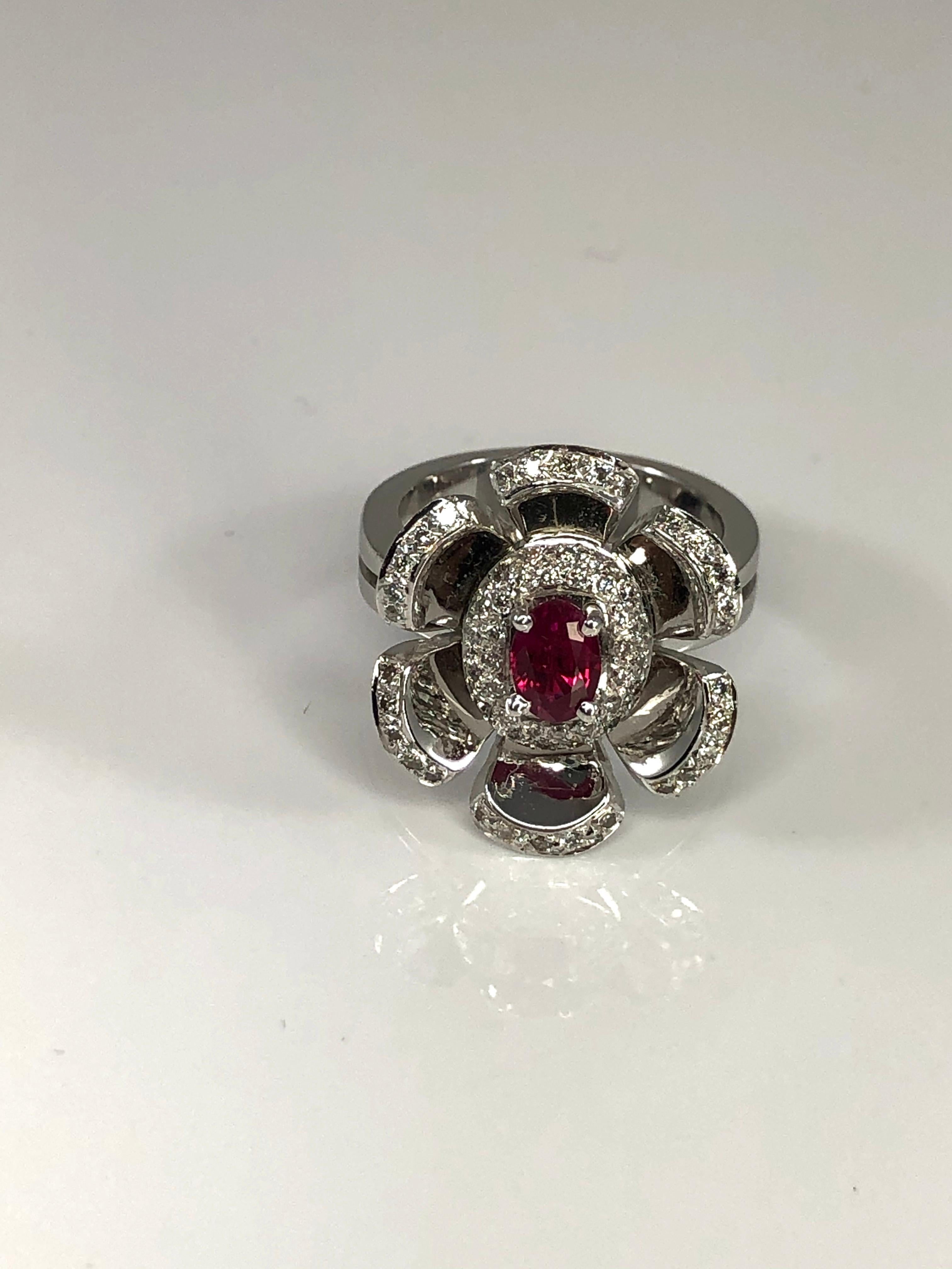 S.Georgios designer floral ring crafted from solid 18 Karat White Gold. This gorgeous piece features a 0.60 Carat oval cut Ruby center and flower petals decorated with 0.65-carat brilliant cut white Diamonds.  
The beautiful Ring can also be ordered