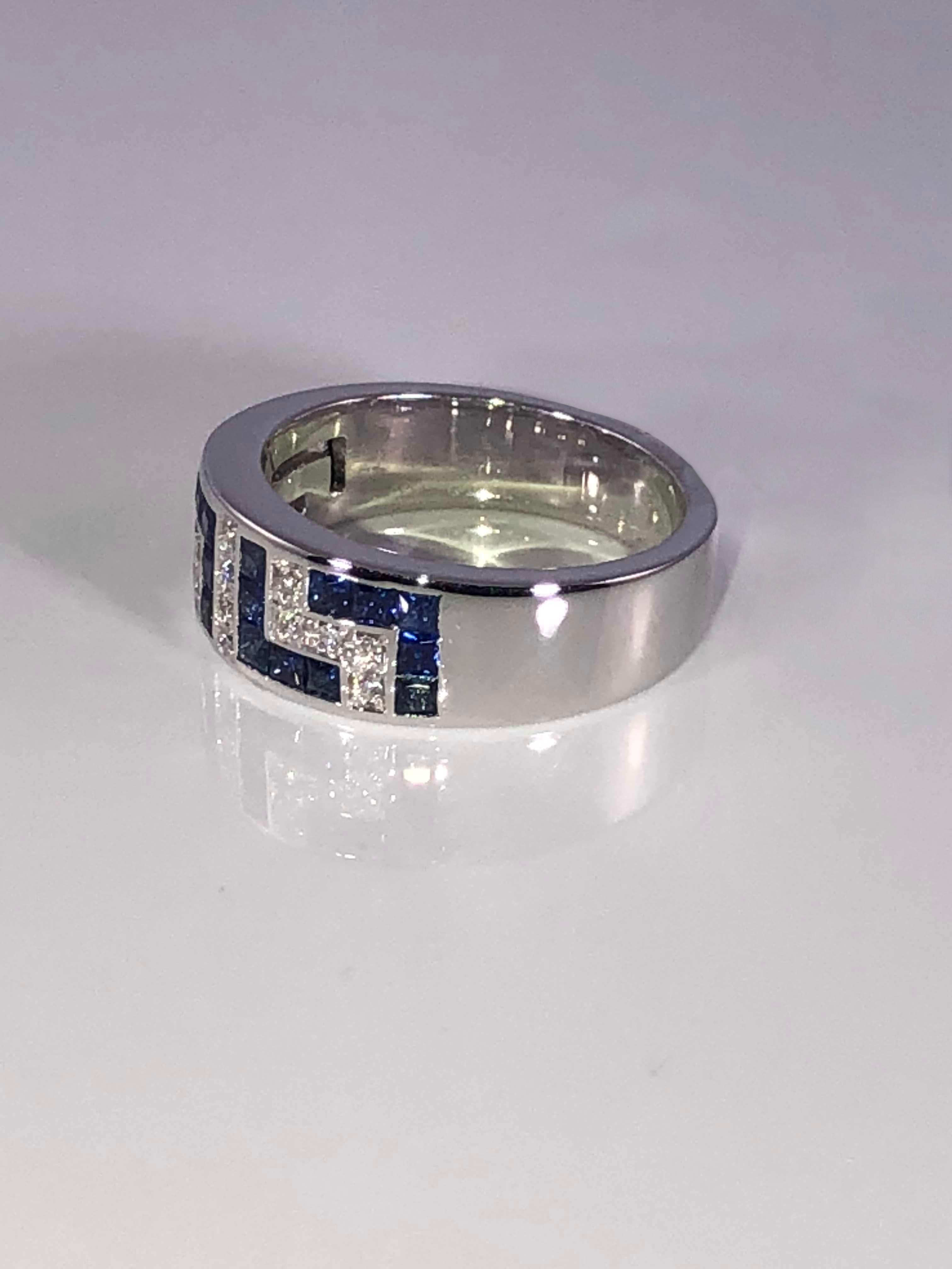 S.Georgios designer 18 Karat White Gold Ring featuring the Greek Key design symbolizing eternity all custom-made. It is decorated with Brilliant Cut White Diamonds total weight of 0.16 Carat, and Princess cut Blue Sapphires total weight of 0.90