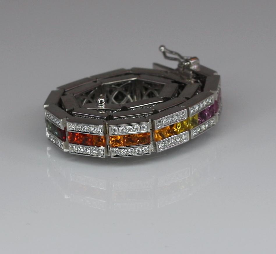 Der Designer S.Georgios präsentiert ein Armband aus massivem 18 Karat Weißgold mit einer Reihe unsichtbar gefasster regenbogenfarbener Saphire im Princess-Schliff mit einem Gesamtgewicht von 9,25 Karat und weißen Diamanten im Brillantschliff an den