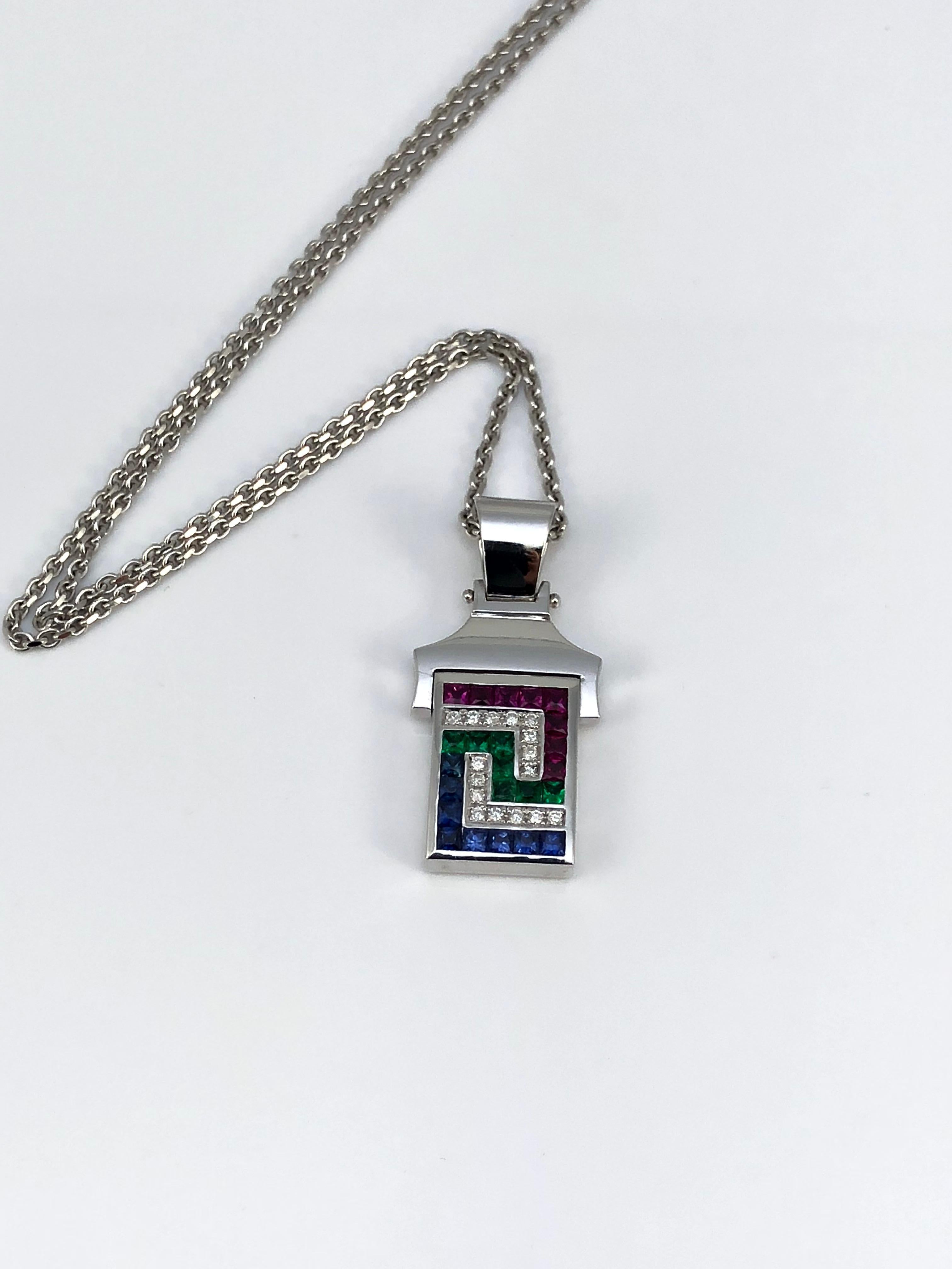S.Georgios designer 18 Karat White Gold Pendant Necklace with Diamonds, Rubies, Sapphires, and Emeralds shaping the Greek Key design, which symbolizes eternity. The beautiful Pendant features Brilliant Cut White Diamonds total weight of 0.13 Carat,