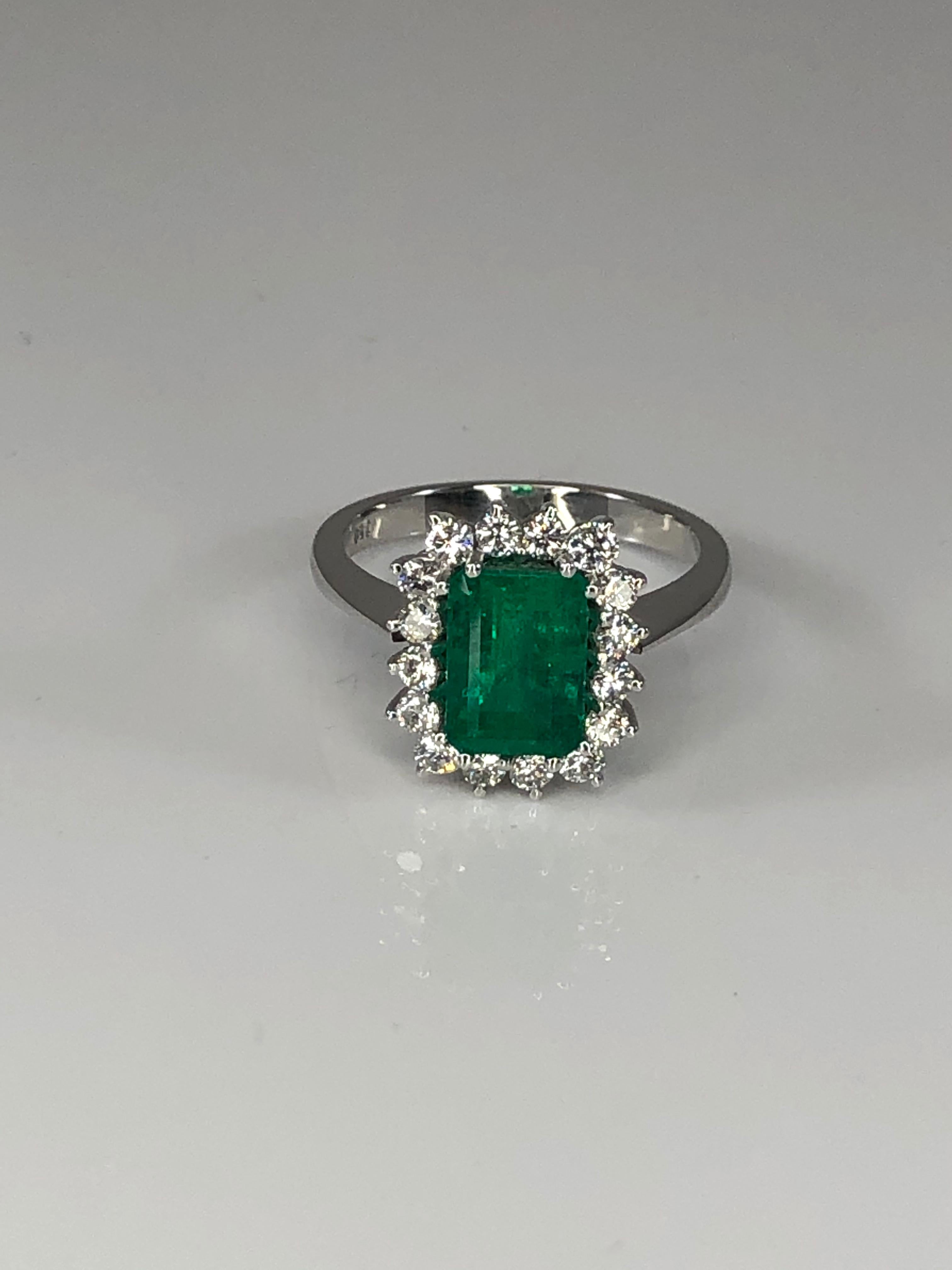 S.Georgios designer classic rosette emerald cut natural emerald with diamonds around. This gorgeous ring is handmade from 18 Karat White gold in Athens Greece and features a 1.95 Carat Natural Emerald accompanied by Brilliant-cut White Diamonds