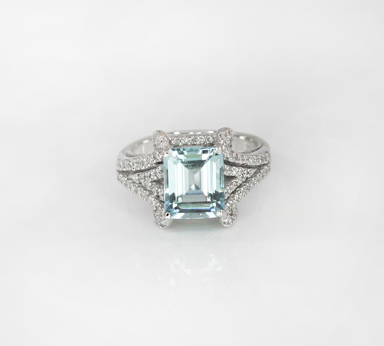 This S.Georgios designer Ring is all hand-made in White Gold 18 Karat. This stunning band ring features a solitaire Emerald cut natural Aquamarine total weight 4.36 Carat, surrounded by natural brilliant cut white Diamonds total weight of 0.40