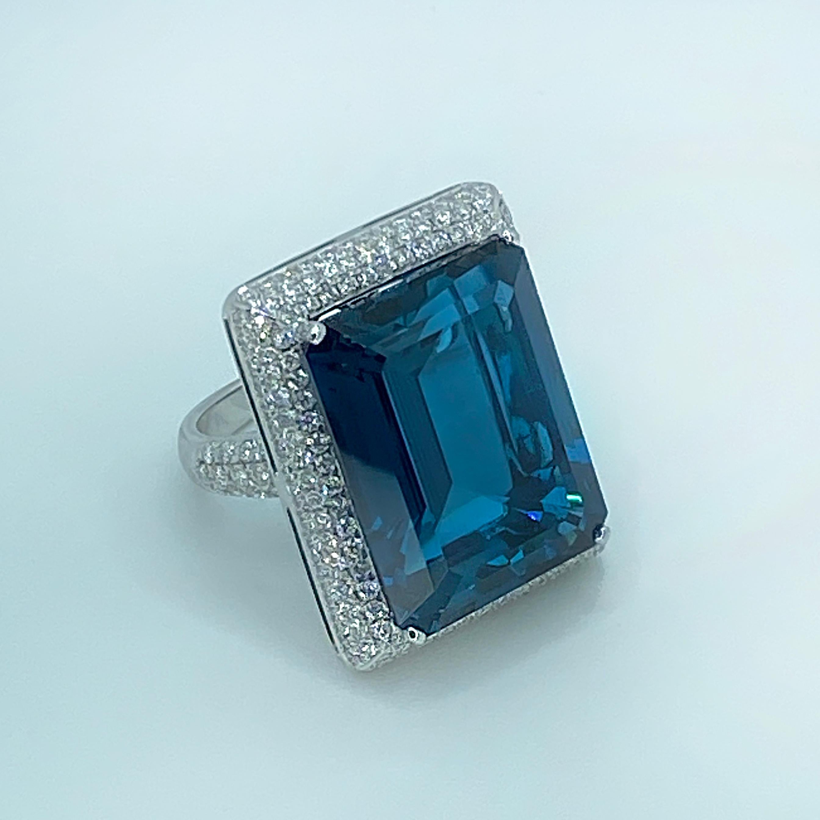 S.Georgios designer Ring is all hand-made in 18 Karat White Gold and features a stunning Spotless Emerald-cut Natural London Blue Topaz total weight 39.41 Carat, surrounded by Brilliant cut VVS clarity and color F white Diamonds total weight of 2.22