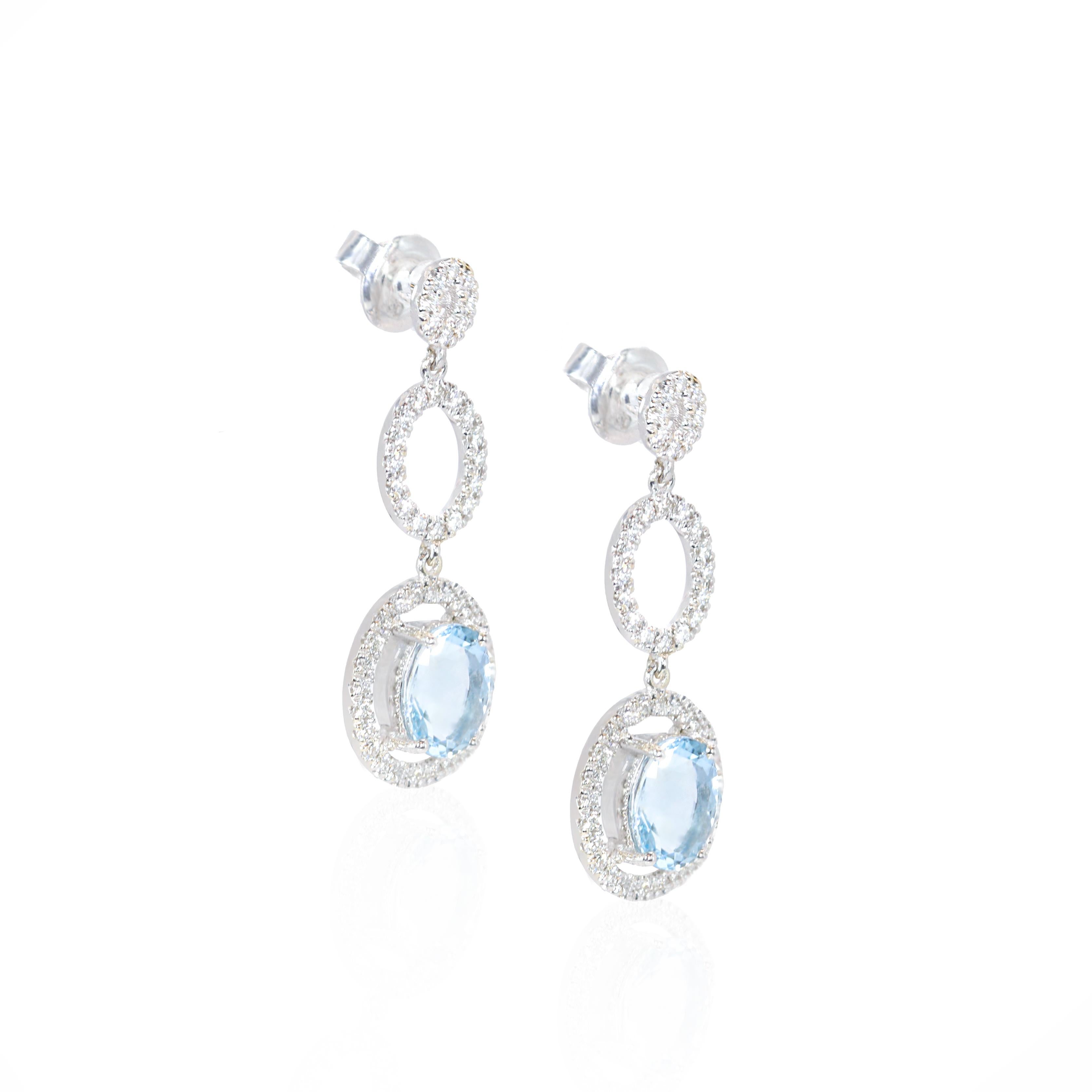 These exquisite 18 Karat White Gold Long Oval Aquamarine Earrings from Georgios Collections are a sophisticated blend of elegance and modernity. They feature a pair of 2.13 Carats oval cut Aquamarines and are adorned with a total of 0.69 carats of