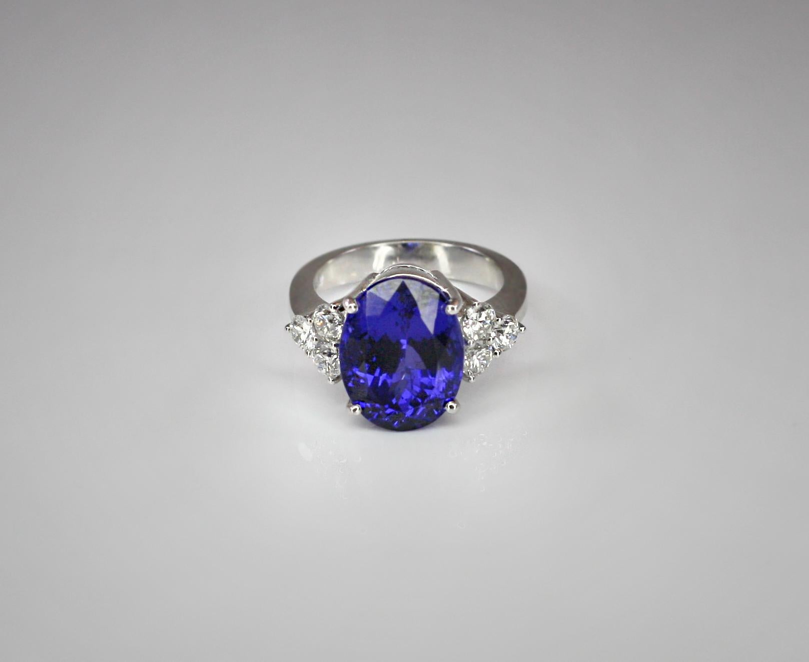 This S.Georgios designer Ring is all hand-made in 18 Karat White Gold and features a stunning color solitaire oval cut natural Tanzanite total weight 9.43 Carat surrounded by 6 natural brilliant cut VVS1 clarity and color F Diamonds total weight of