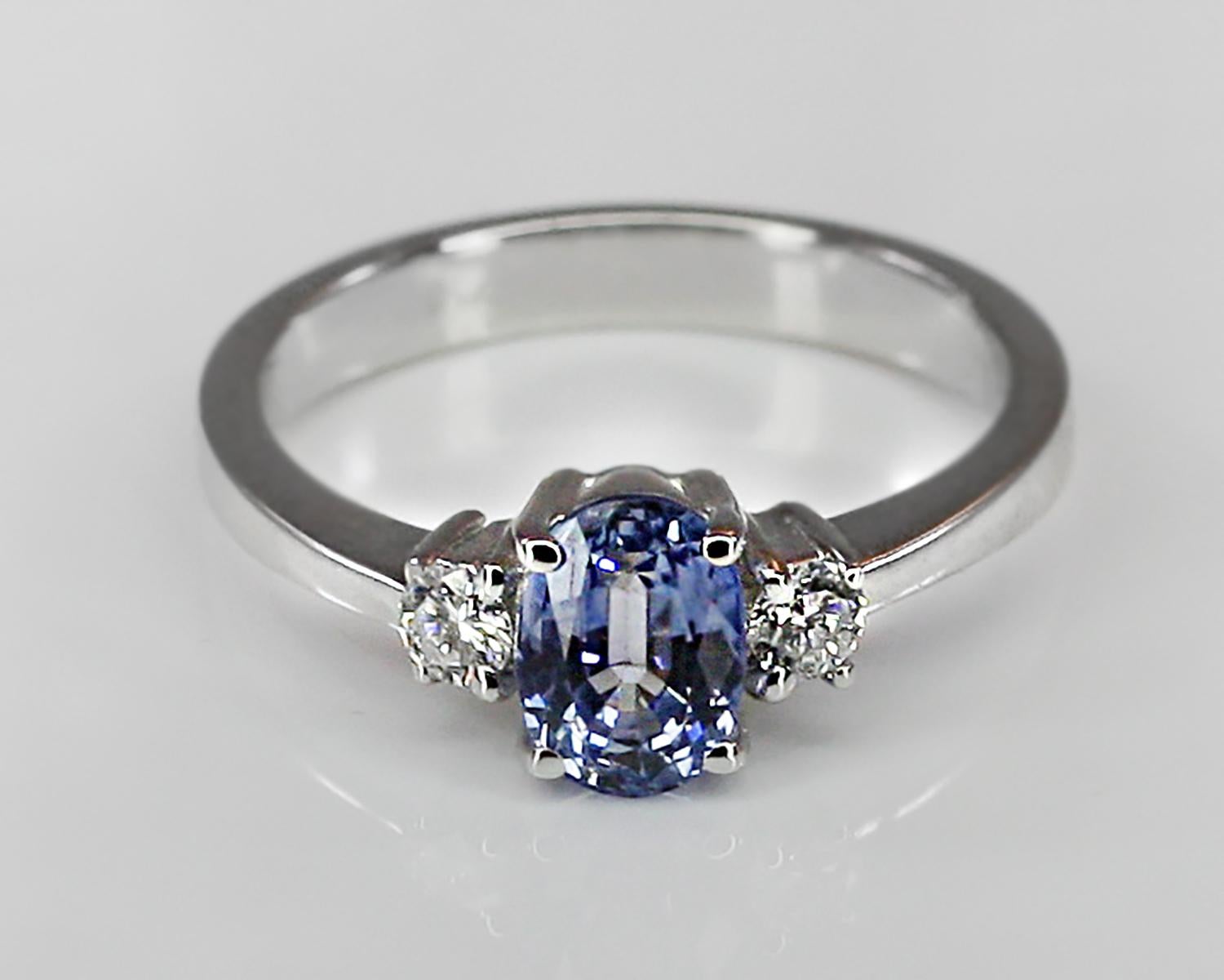 This S. Georgios designer Ring in White Gold 18 Karat is hand made with elegant microscopic settings and features a solitaire oval cut natural Sapphire total weight 0.95 Carat, surrounded by 2 brilliant cut white Diamonds total weight of 0.20 Carat.