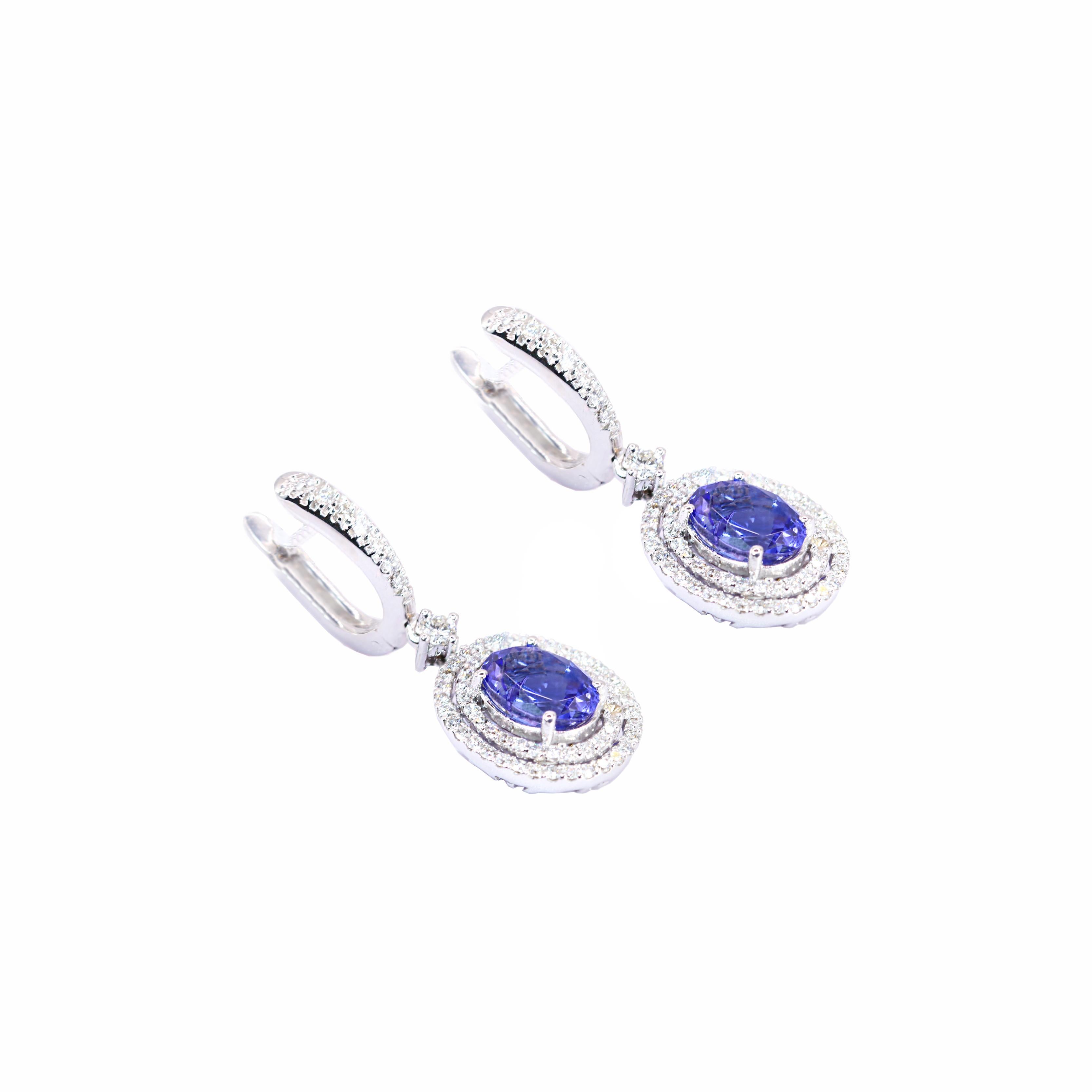 These exquisite 18 Karat White Gold Long Oval Tanzanite Earrings from Georgios Collections are a sophisticated blend of elegance and modernity. They feature a pair of 2.90 Carats oval cut Tanzanites and are adorned with a total of 0.83 carats of
