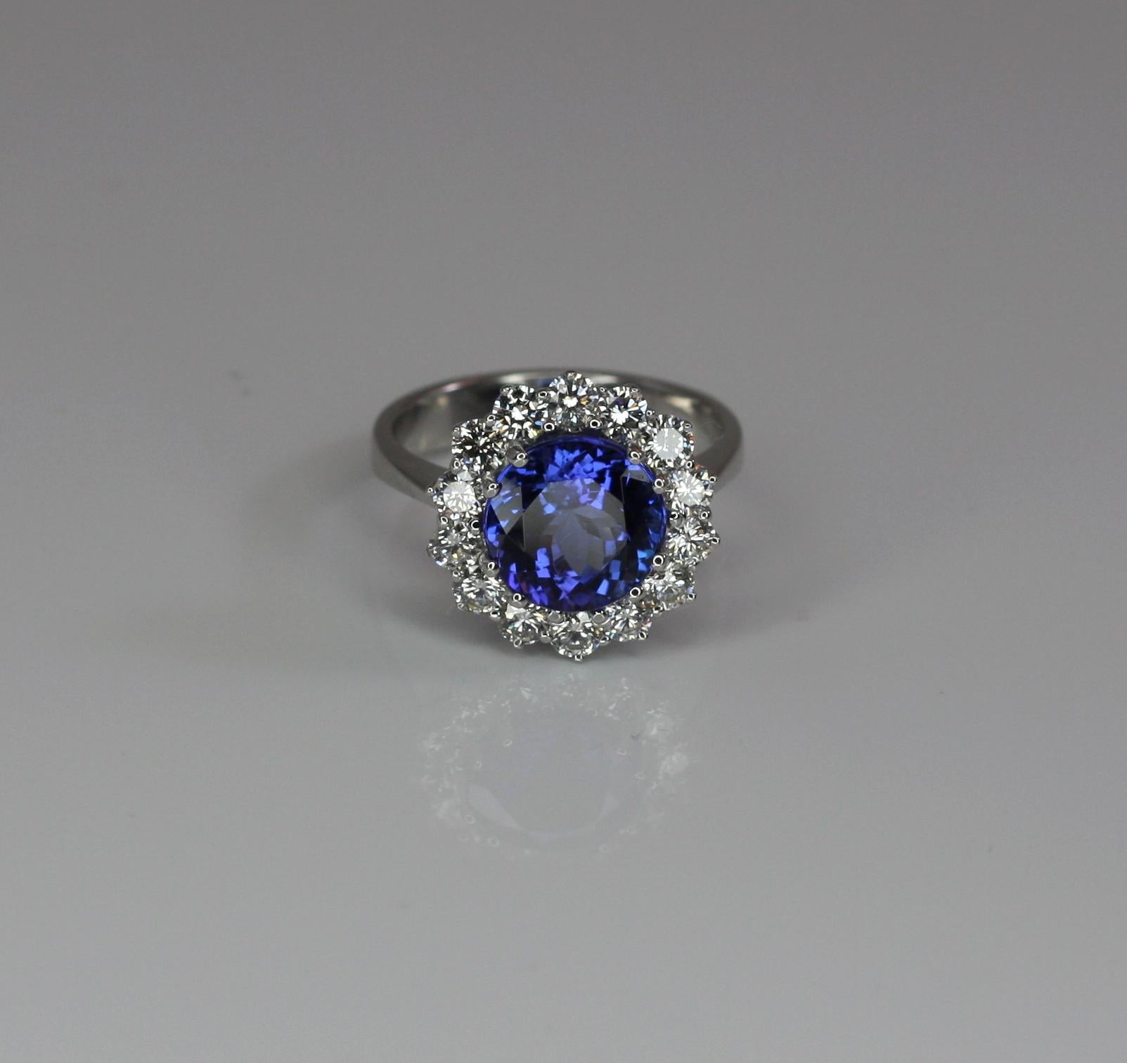 S.Georgios klassischer Rosettenring mit Tansanit und Diamant. Dieser wunderschöne Ring zeigt einen exquisiten 4,47 Karat natürlichen Tansanit im Rundschliff, begleitet von weißen Diamanten im Brillantschliff VVS2 Farbe F, mit einem Gesamtgewicht von