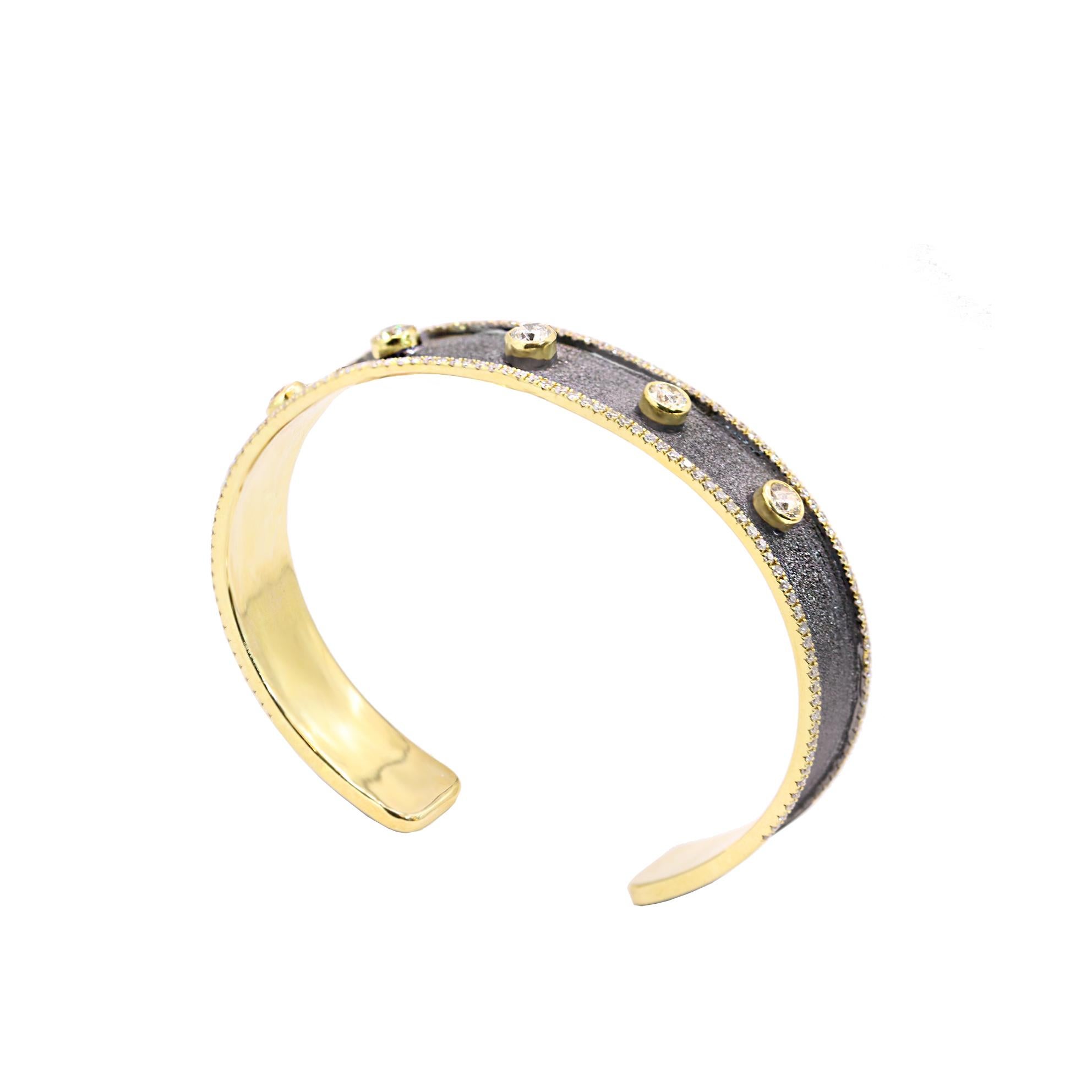 Der Designer S.Georgios präsentiert einen exquisiten Armreif aus 18 Karat Gelbgold mit schwarzer Rhodiumoberfläche. Dieses atemberaubende Armband zeichnet sich durch fünf Diamanten im Brillantschliff aus, die elegant über die gesamte Länge verteilt