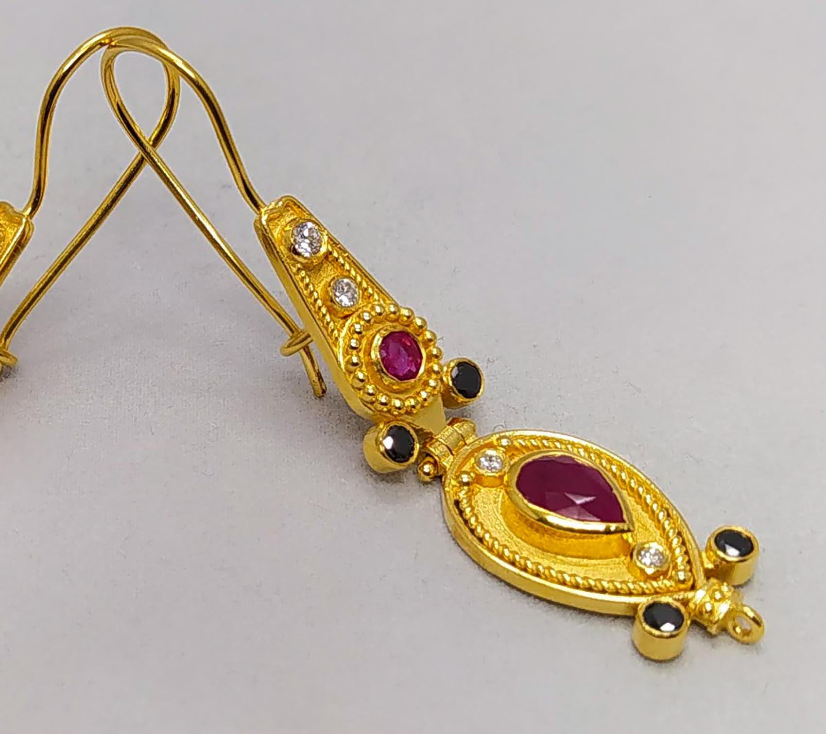 Die Ohrringe aus 18 Karat Gelbgold im byzantinischen Stil von S.Georgios werden in mikroskopischer Granulationsarbeit von Hand gefertigt und mit einem einzigartigen Samtuntergrund versehen. 
Das wunderschöne Paar besteht aus 2 natürlichen Rubinen im