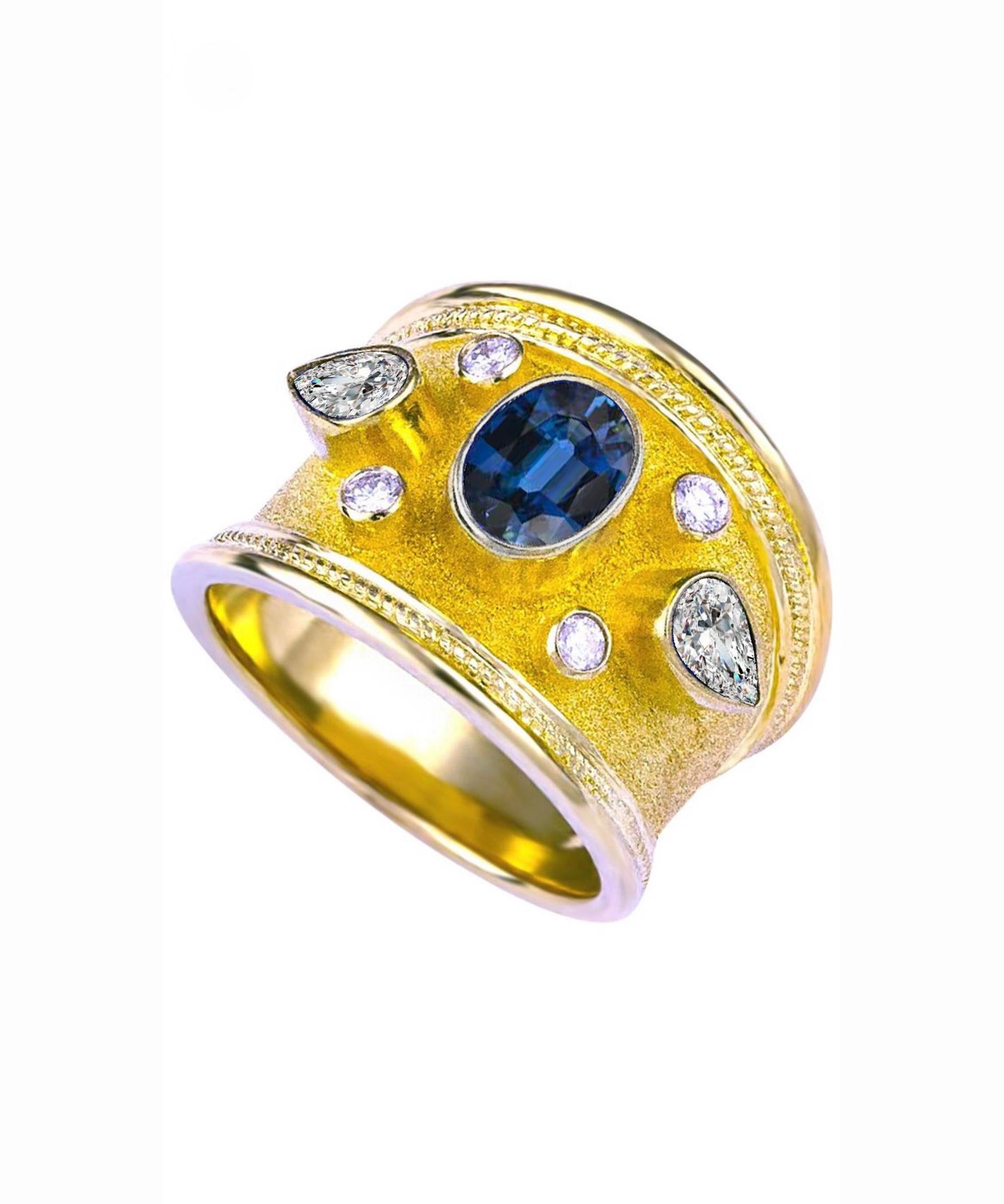 S.Georgios Hand Made 18 Karat Yellow Gold Ring decorated with Byzantine-style granulation and the unique velvet finish on the background. The stunning ring features in the center an Oval Blue Sapphire the weight of 1,46 Carat, 4 Brilliant cut White