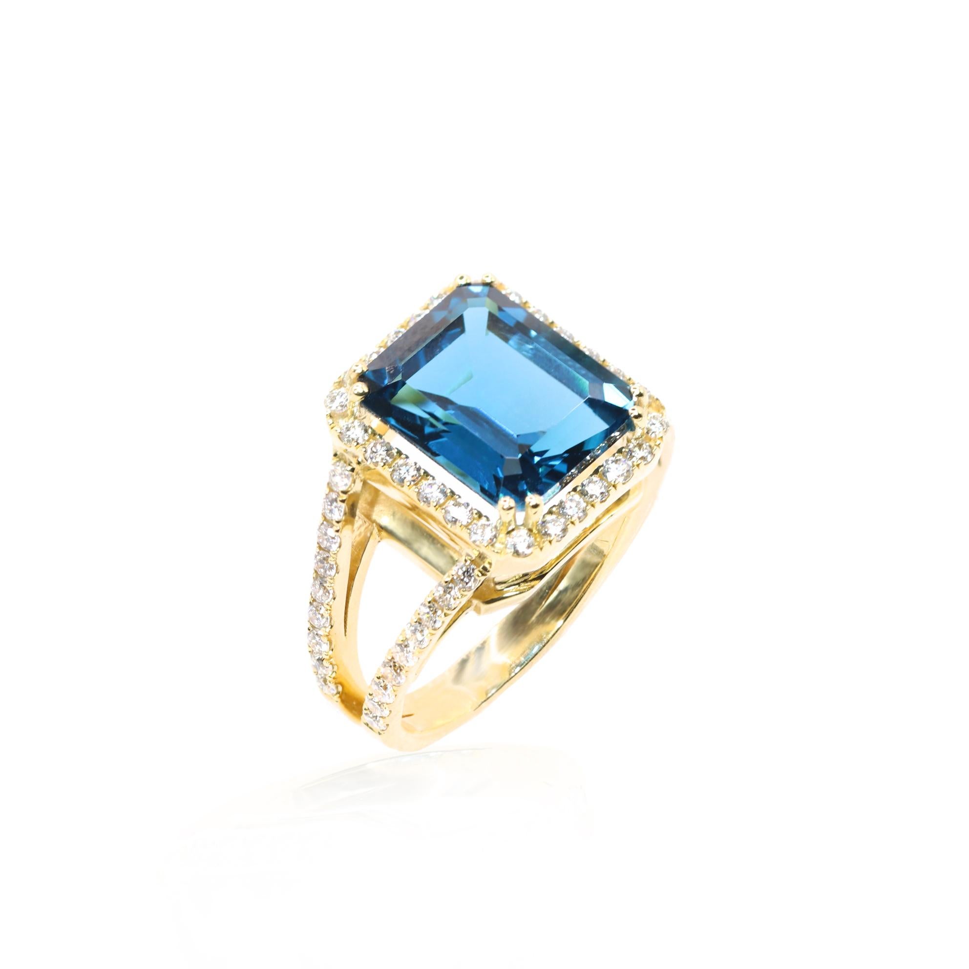 S.Georgios designer presents an exquisite 18 Karat White Gold ring featuring an emerald-cut 7.84 Carats Blue Topaz at its center, framed by a dazzling bezel of White Diamonds, total weight of 0.91 Carats. The Blue Topaz boasts a rich, vibrant blue