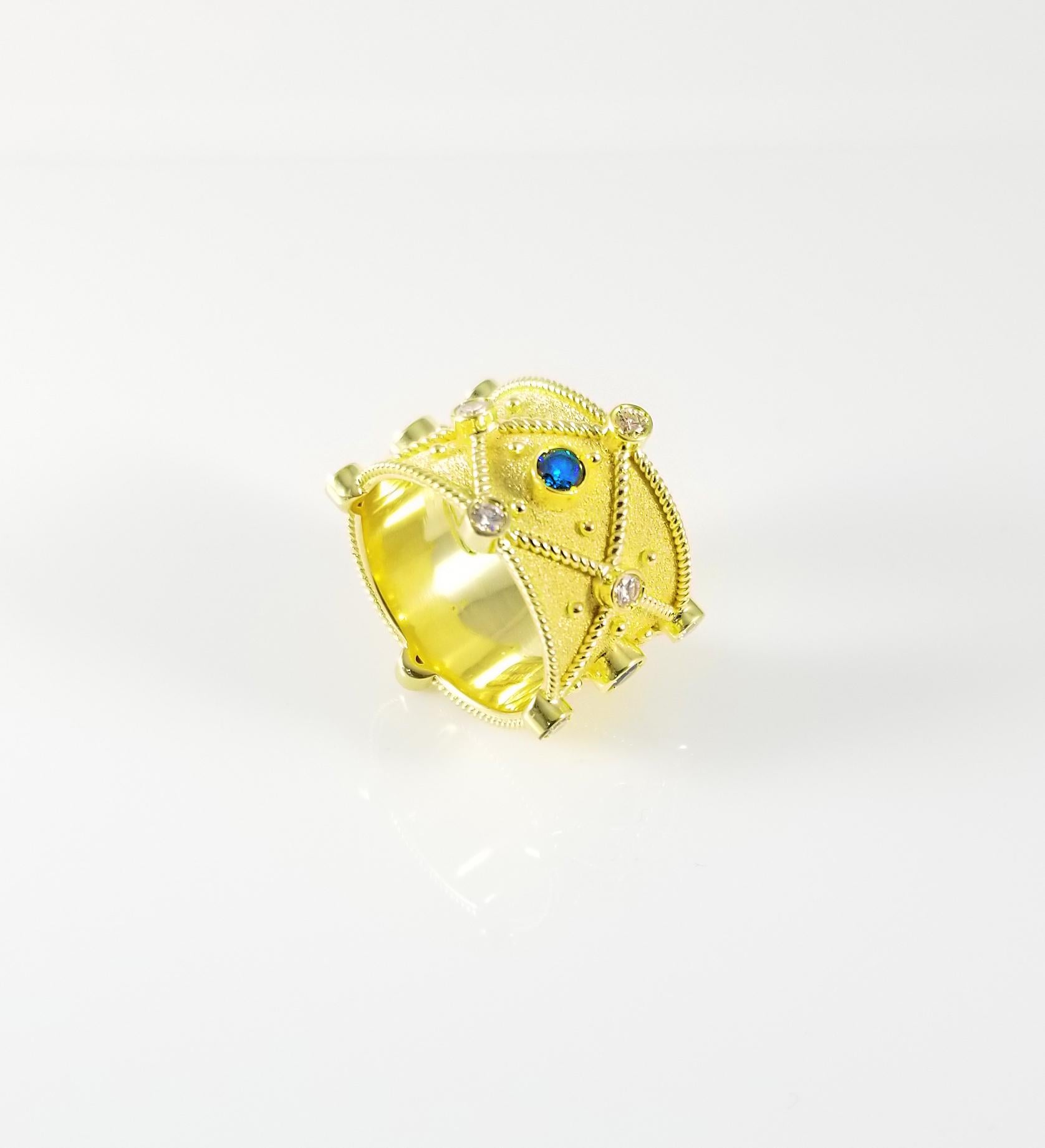 S.Georgios designer ring handmade from solid 18 Karat Yellow Gold and is microscopically decorated all the way around with gold beads and wires and has a unique velvet look on the background. This gorgeous piece features 4 Brilliant cut Blue
