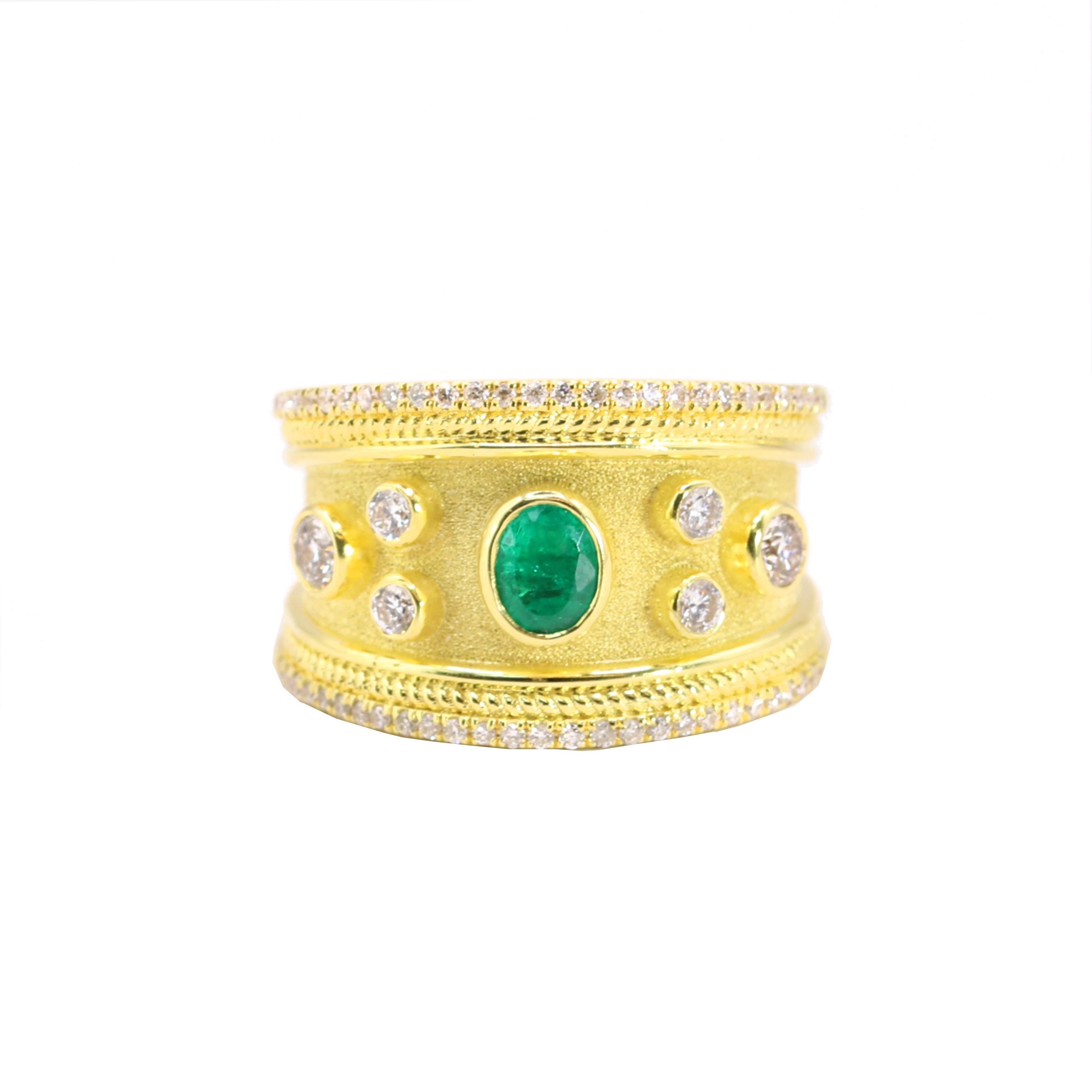 Le designer S.Georgios présente une élégante bague en or jaune 18 carats ornée d'une superbe émeraude de taille ovale de 0,33, accompagnée de six diamants blancs de taille brillant, pour un poids total de 0,56 carats. La bague est ornée d'un fond en