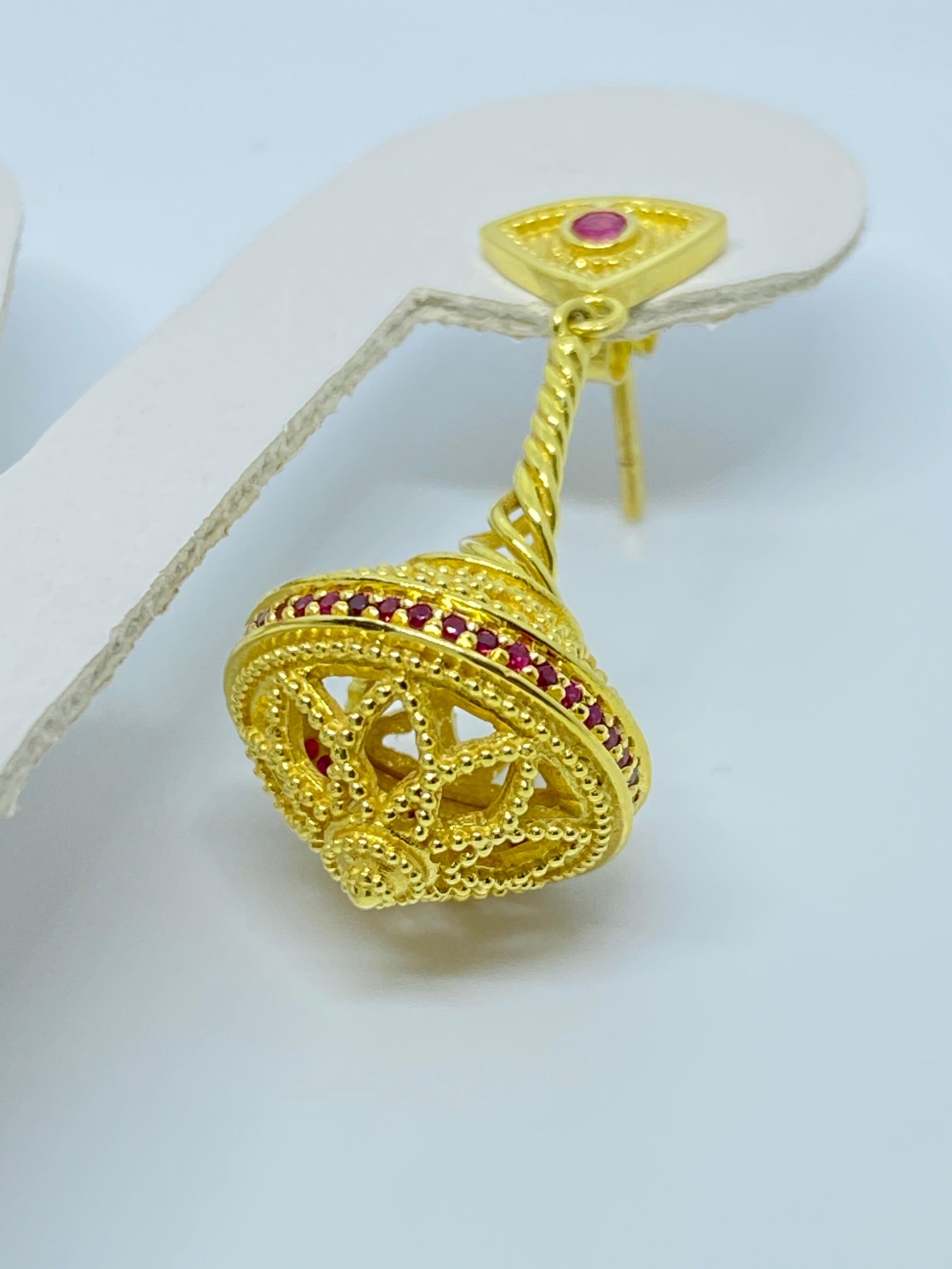 These S.Georgios designer earrings are hand made from 18 Karat Yellow Gold and decorated with Byzantine-era style granulation workmanship. This beautiful and elegant pair feature 2 rows of microscopically set Rubies total weight of 0.87 Carats,