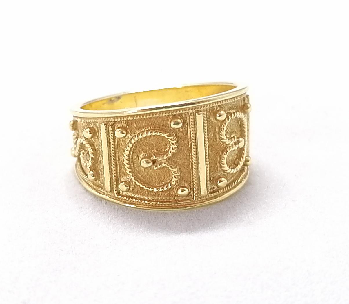 S.Georgios designer band ring is made from solid 18 Karat Yellow Gold and is microscopically decorated with handmade granulation work to create a stunning and elegant art piece. We have finished this beautiful band with a unique velvet background to
