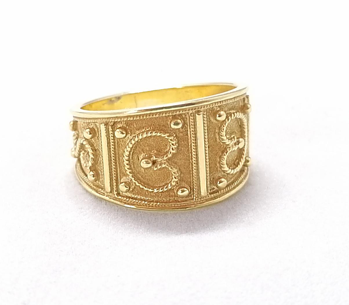 S.Georgios Designerring ist aus massivem 18 Karat Gelbgold gefertigt und mikroskopisch mit handgefertigter Granulierung verziert, um ein atemberaubendes und elegantes Kunstwerk zu schaffen. Wir haben dieses wunderschöne Band mit einem einzigartigen