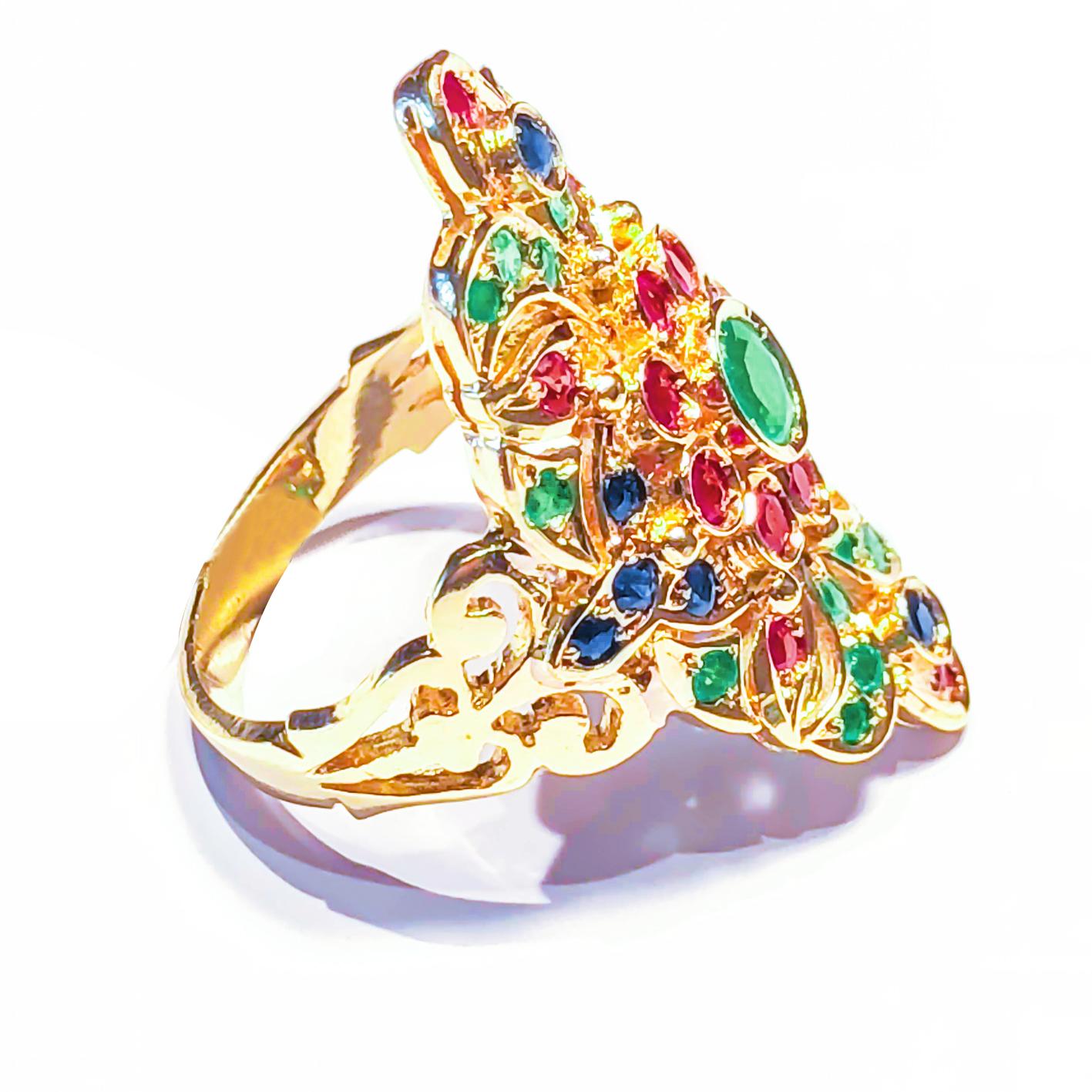Bague en or jaune 18 carats fabriquée à la main par S.Georgios, décorée de granulations de style byzantin et d'une combinaison de rubis, d'émeraudes et de saphirs.
Elle comporte des rubis, des saphirs et une émeraude au centre, pour un poids total