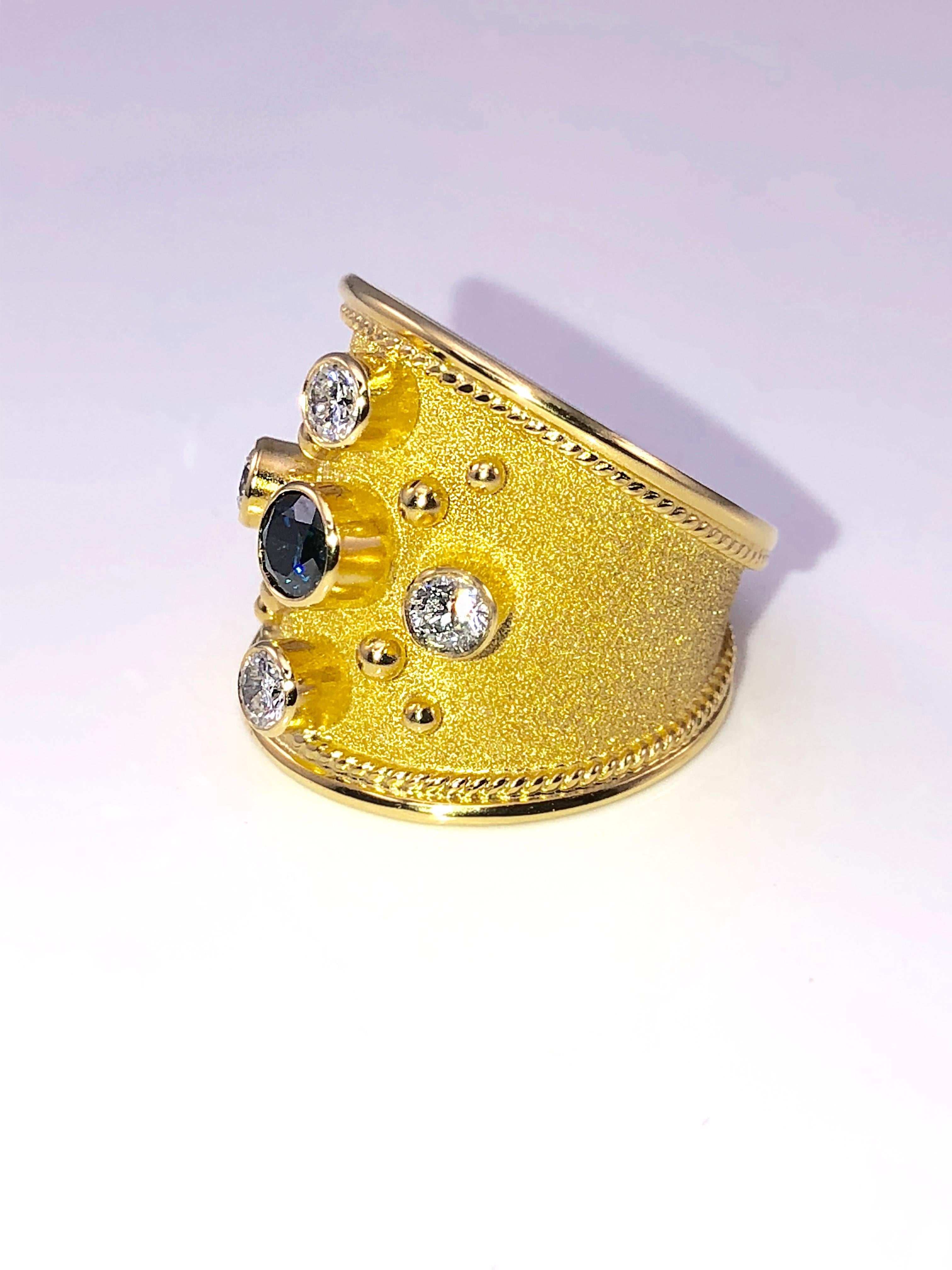 Einzigartiger S.Georgios Designer-Ring aus 18 Karat Gelbgold, handgefertigt mit byzantinischer Granulierung und einem wunderschönen Samt-Finish auf dem Hintergrund. Der wunderschöne Ring hat einen blauen Diamanten im Brillantschliff mit einem