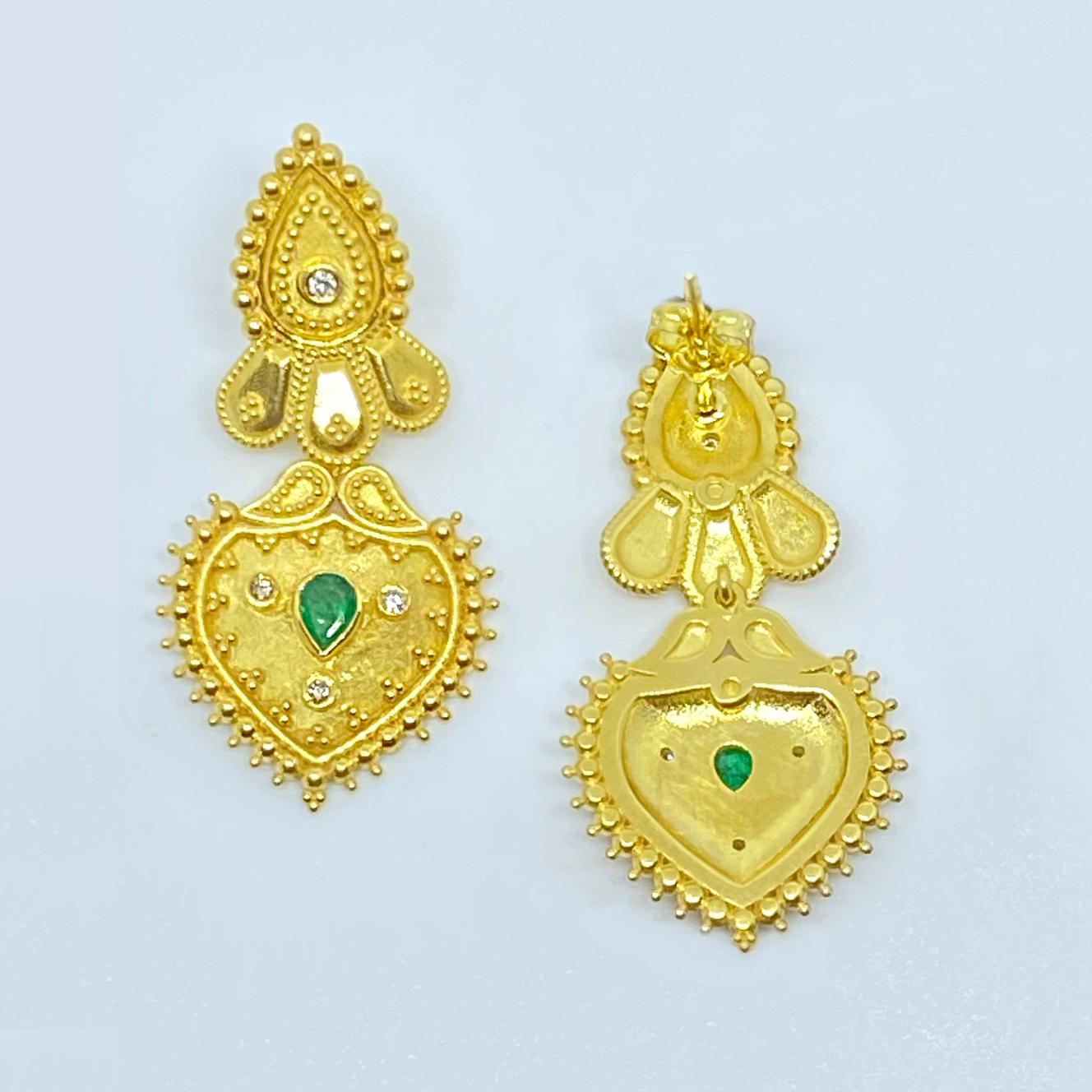 Questi orecchini firmati S.Georgios sono realizzati a mano in oro giallo 18 carati e sono decorati con una lavorazione a granulazione in stile bizantino e presentano diamanti a taglio brillante per un peso totale di 0,26 carati e 2 smeraldi naturali