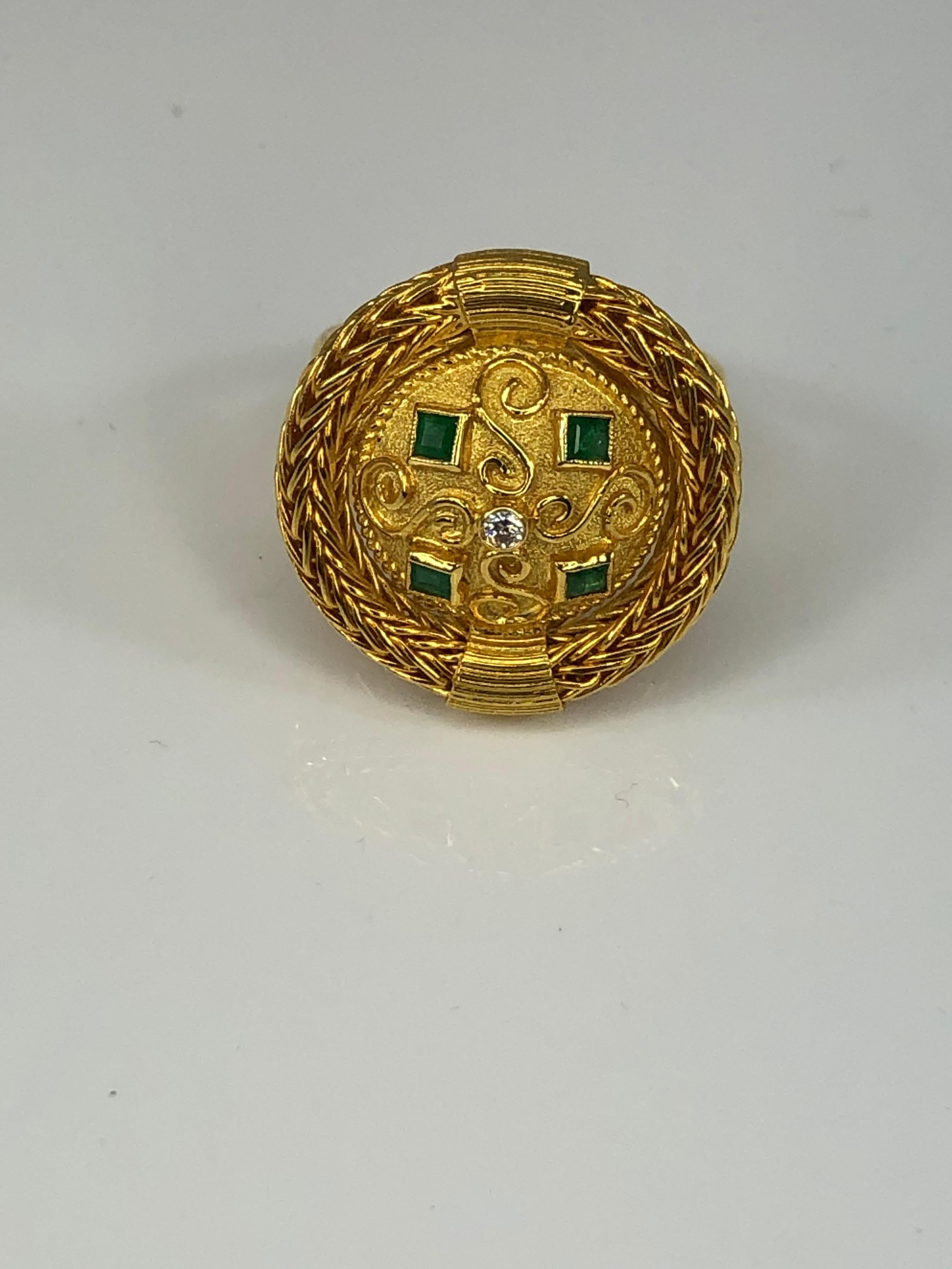 S.Georgios designer 18 Karat yellow gold ring handmade and decorated with Byzantine-style granulation and hand-knitted rope all around the edge. The center decorates 0.02 Carat brilliant cut diamond and 4 princess cut emeralds total weight of 0,24