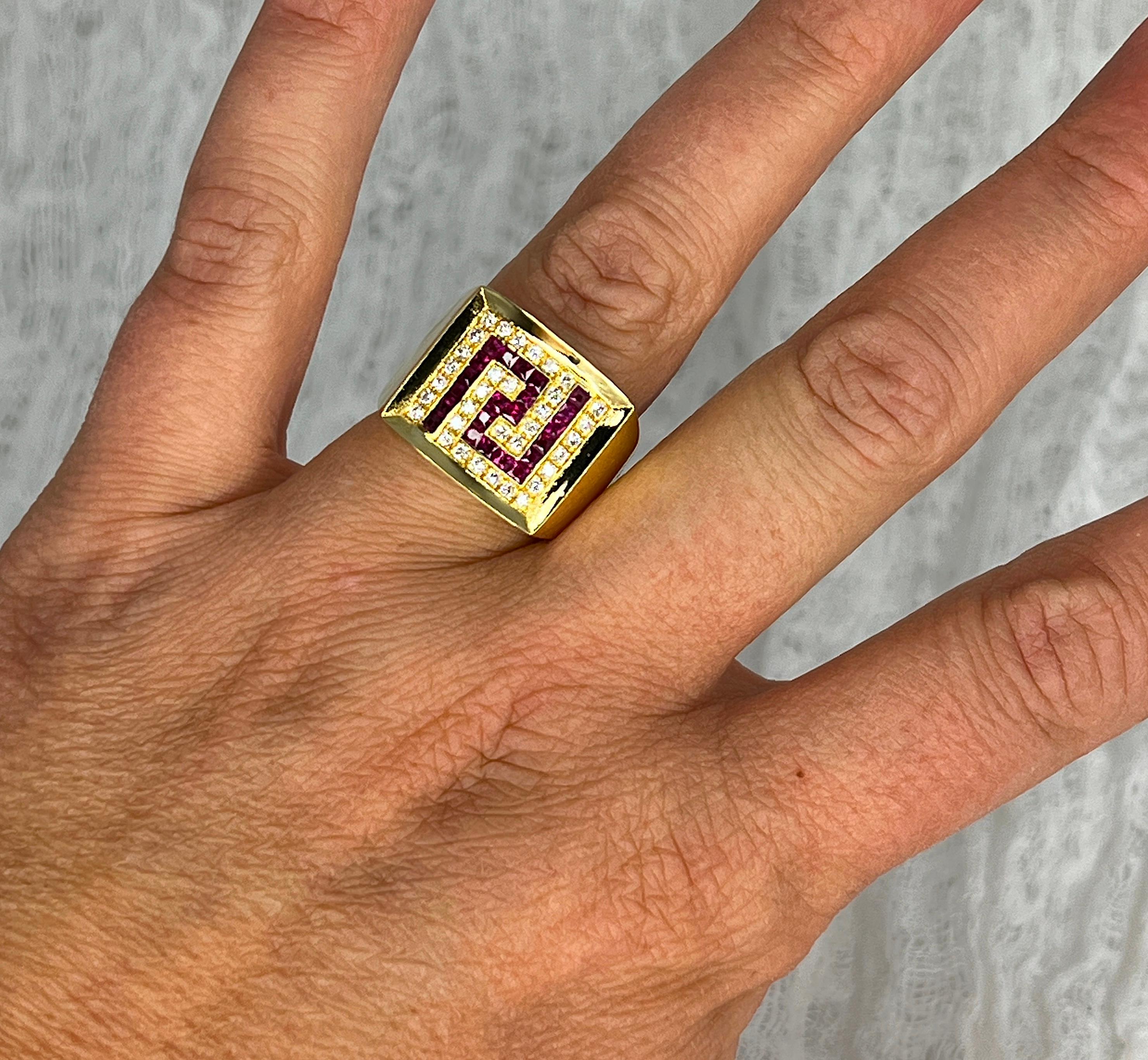 This S.Georgios designer 18 Karat Yellow Gold Ring features the Greek Key design symbolizing eternity. It is all Hand Made and has Brilliant Cut White Diamonds with a total weight of 0.32 Carat, and Princess-cut Rubies in an invisible setting with a