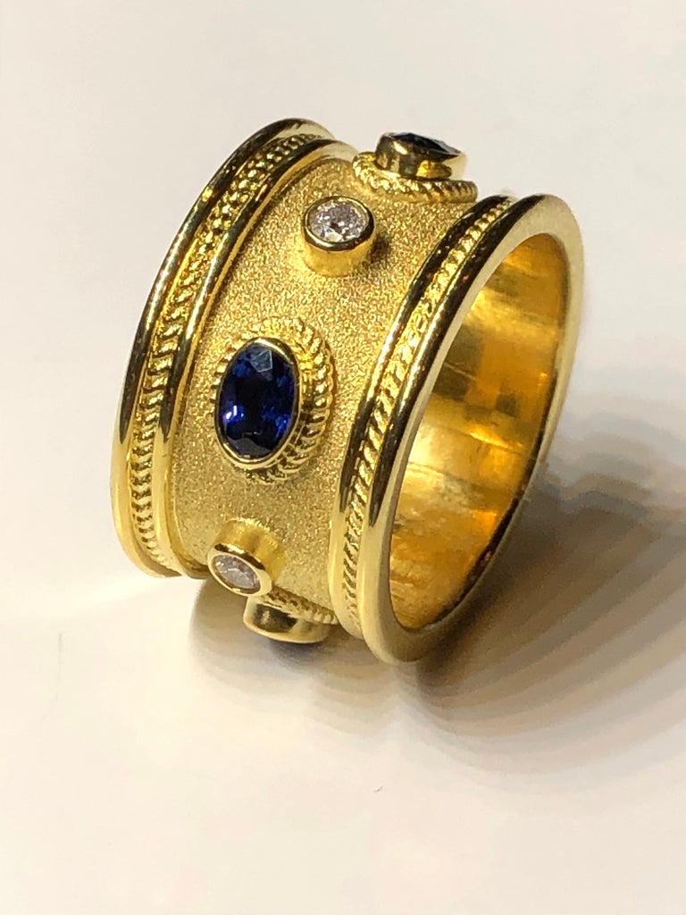 This S.Georgios designer 18 Karat Yellow Gold Band Ring is all handmade with Byzantine workmanship - granulation and is finished with a unique velvet background. This gorgeous band ring features 4 Brilliant cut White Diamonds total weight of 0.29