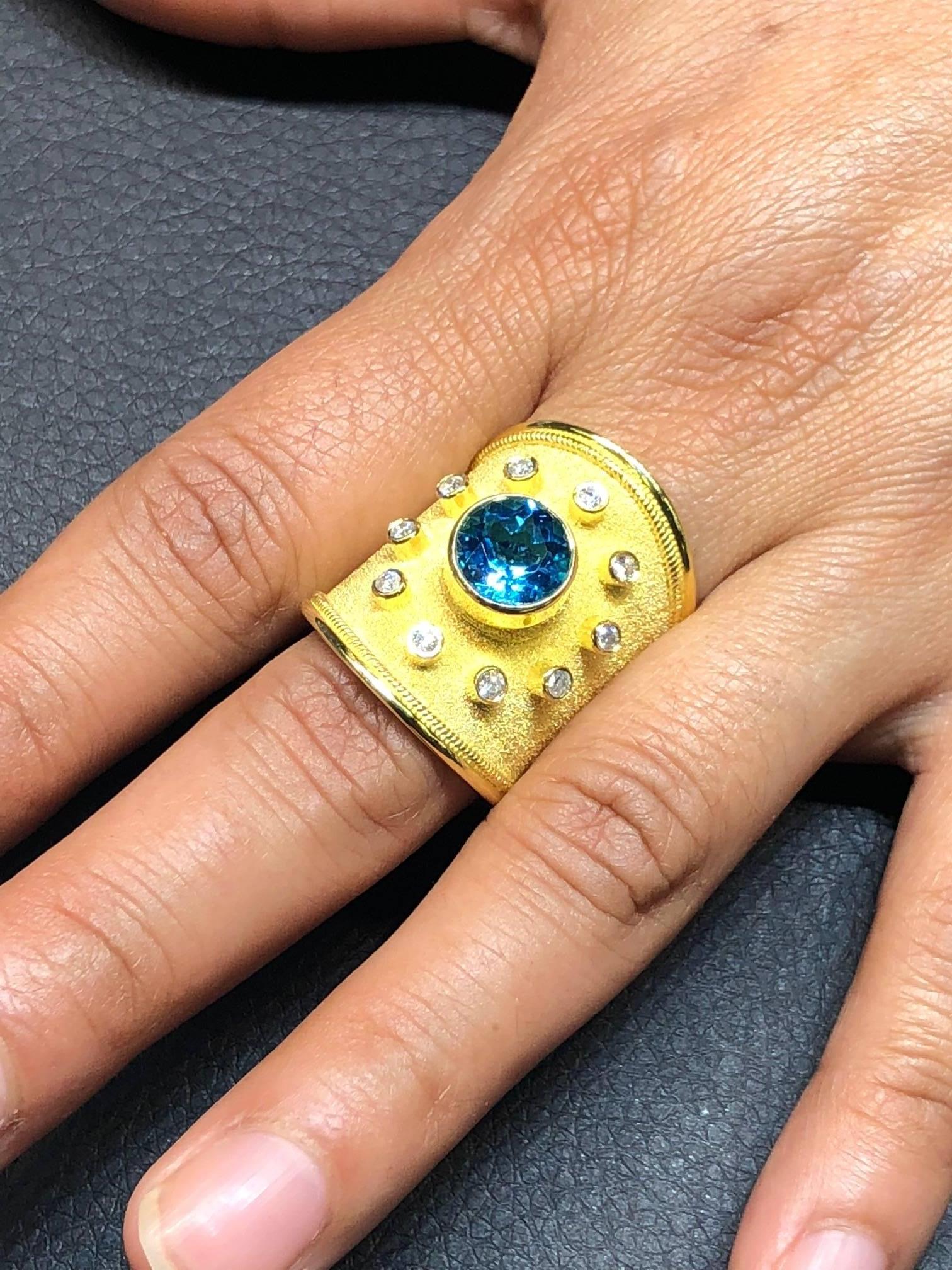S.Georgios designer 18 Karat Solid Yellow Gold Ring all handmade with the Byzantine Granulation workmanship and a unique velvet background. The ring features a Brilliant cut Sky Blue Topaz total weight of 3.28 Carat and 10 brilliant-cut White