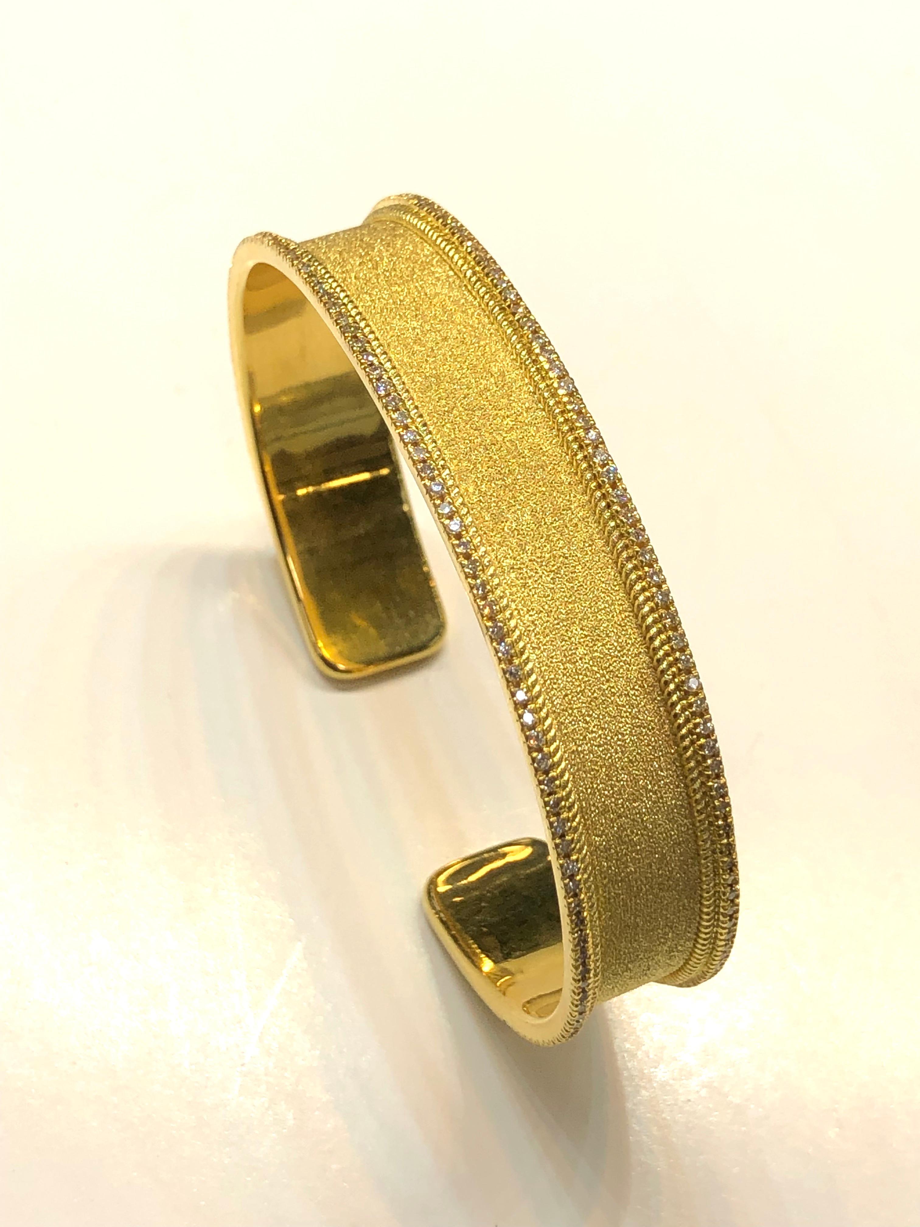 S.Georgios designer bangle bracelet hand made in 18 Karat yellow gold. This bracelet is finished in Byzantine style with the unique velvet look on the background. The bracelet features brilliant cut white diamonds total weight of 0.86 Carat around