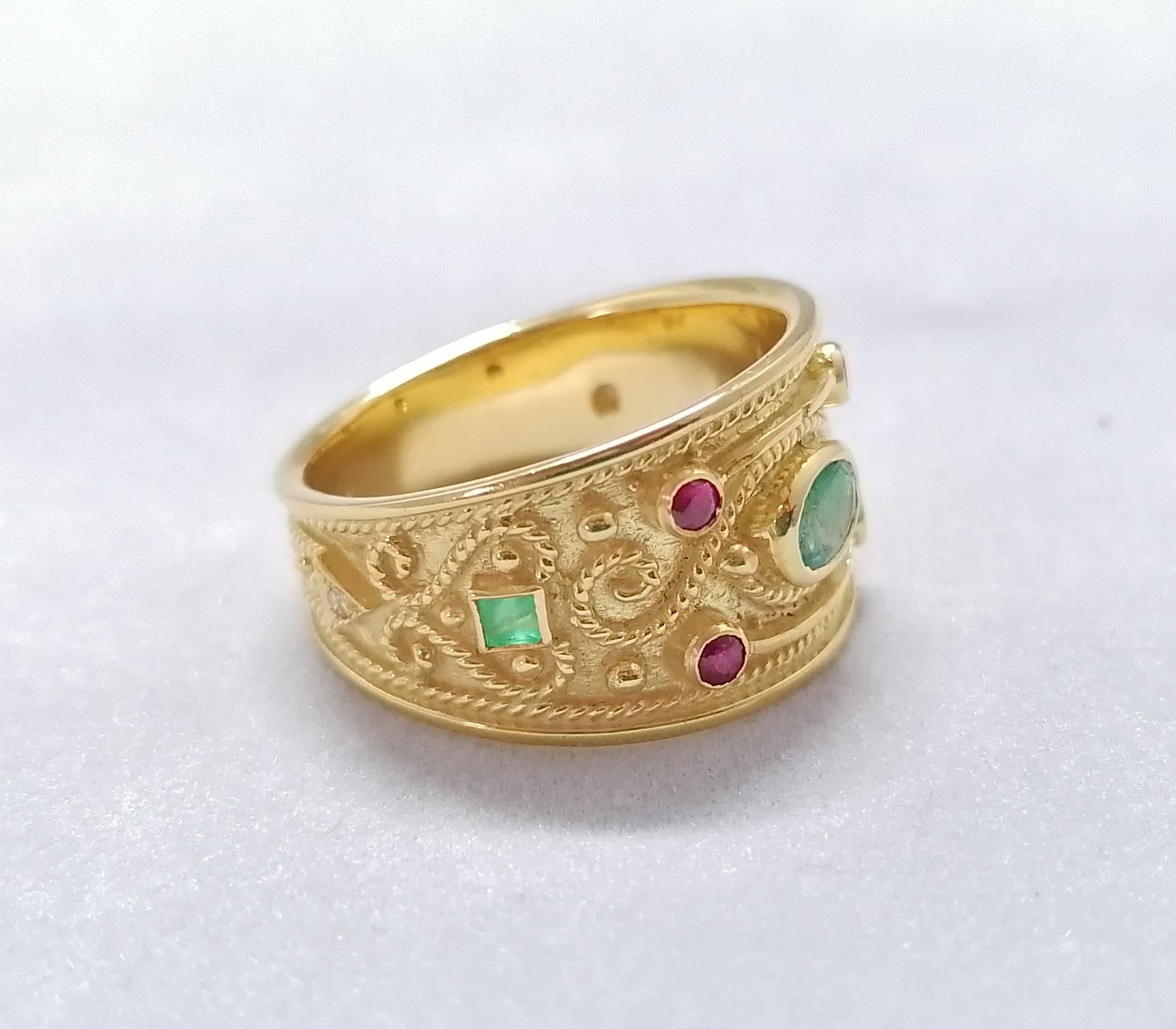 This S.Georgios designer 18 Karat Yellow Gold Multicolor band Ring is all handmade with Byzantine-style bead granulation and a unique velvet background. This gorgeous band ring features an Oval cut natural Emerald, framed by 2 square cut Emeralds