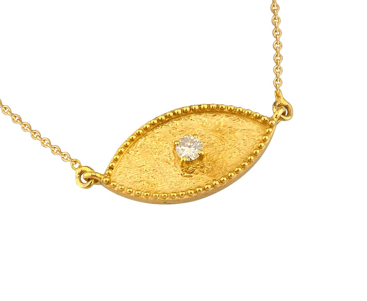 This S.Georgios designer pendant necklace is 18 Karat yellow gold and microscopically decorated with hand-made bead granulation workmanship, and finished with a unique velvet background look. This beautiful oval Evil Eye pendant necklace features a