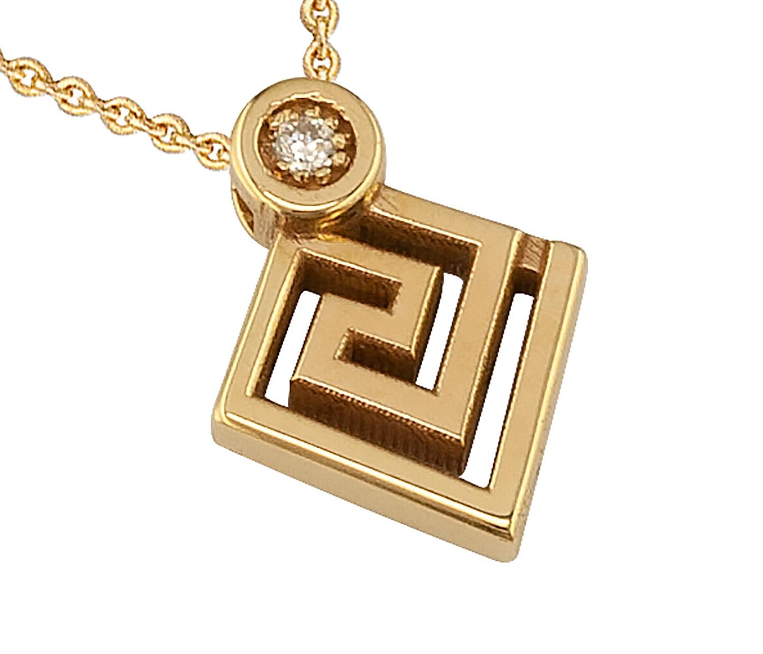 Le collier à pendentifs de S.Georgios est fabriqué à la main en or jaune 18 carats massif et sculpté pour former le motif de la clé grecque, symbole de l'éternité. Ce magnifique collier pendentif est orné d'un diamant blanc taille brillant d'un