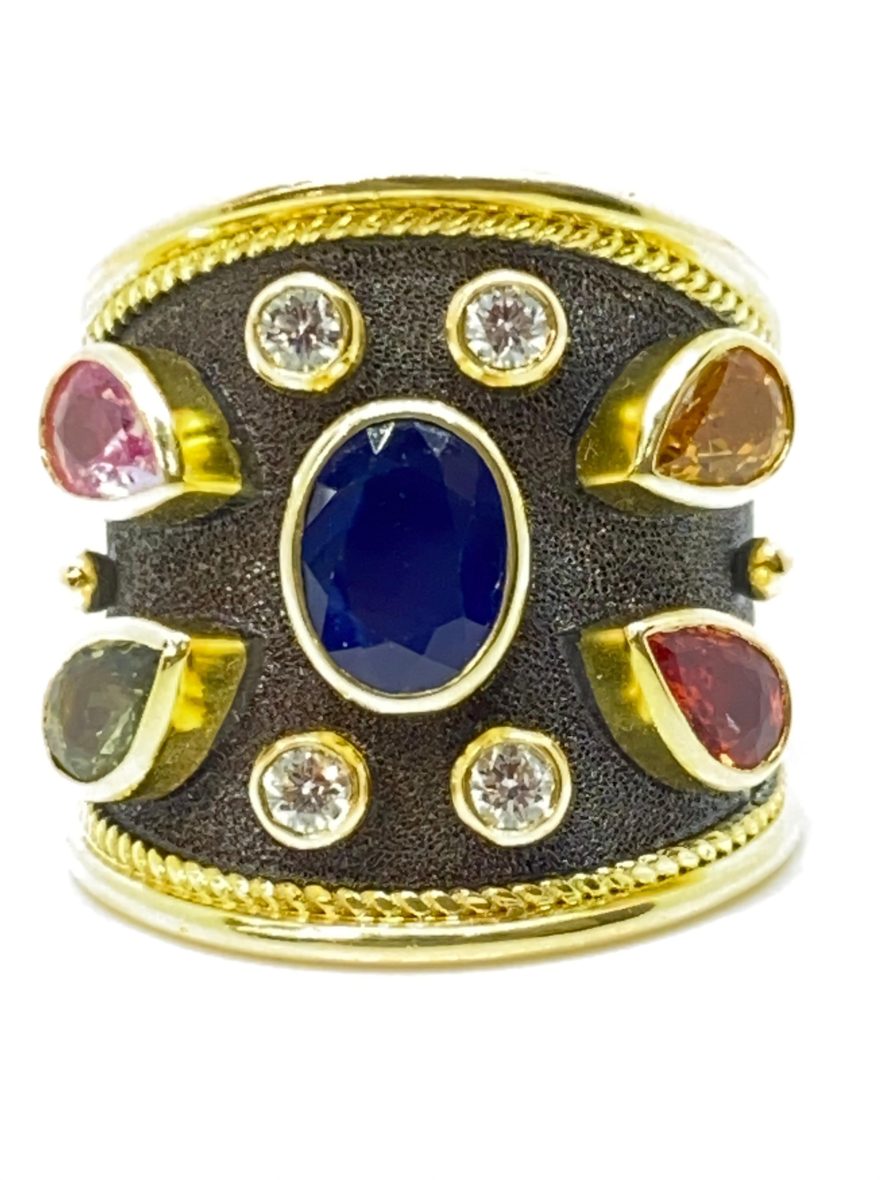 This S.Georgios unique designer Band Ring is 18 Karat Yellow Gold and all handmade with granulation and a unique velvet background finished in Black Rhodium. This gorgeous band ring features an Oval cut Blue Sapphire total weight of 1.20 Carat