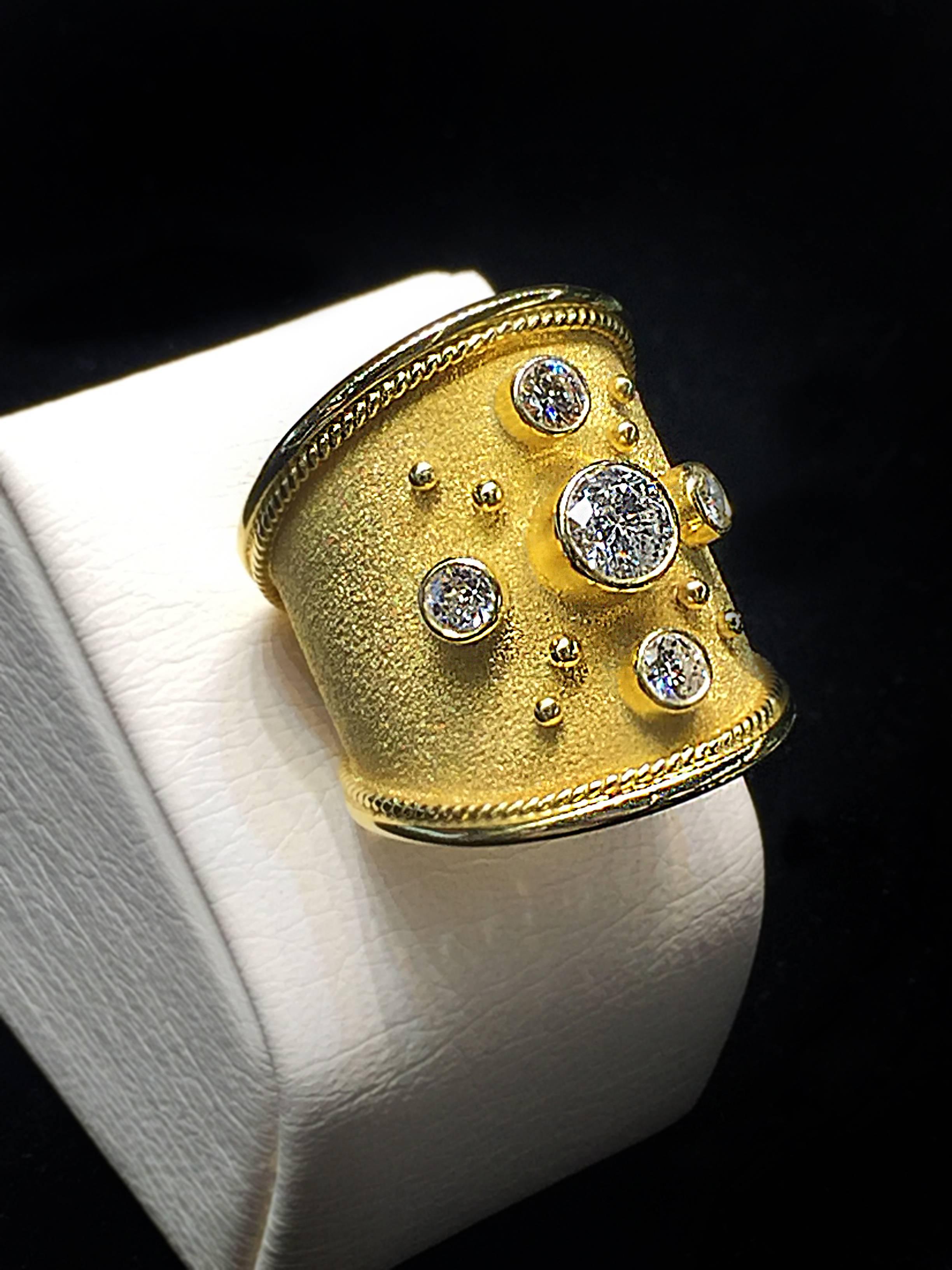 S.Georgios designer 18 Karat Yellow Gold Wide Band Ring is all hand made and has Byzantine granulation beads and wires from 22 Karat gold and a unique velvet look on the background done all microscopic. The gorgeous ring features a center Brilliant