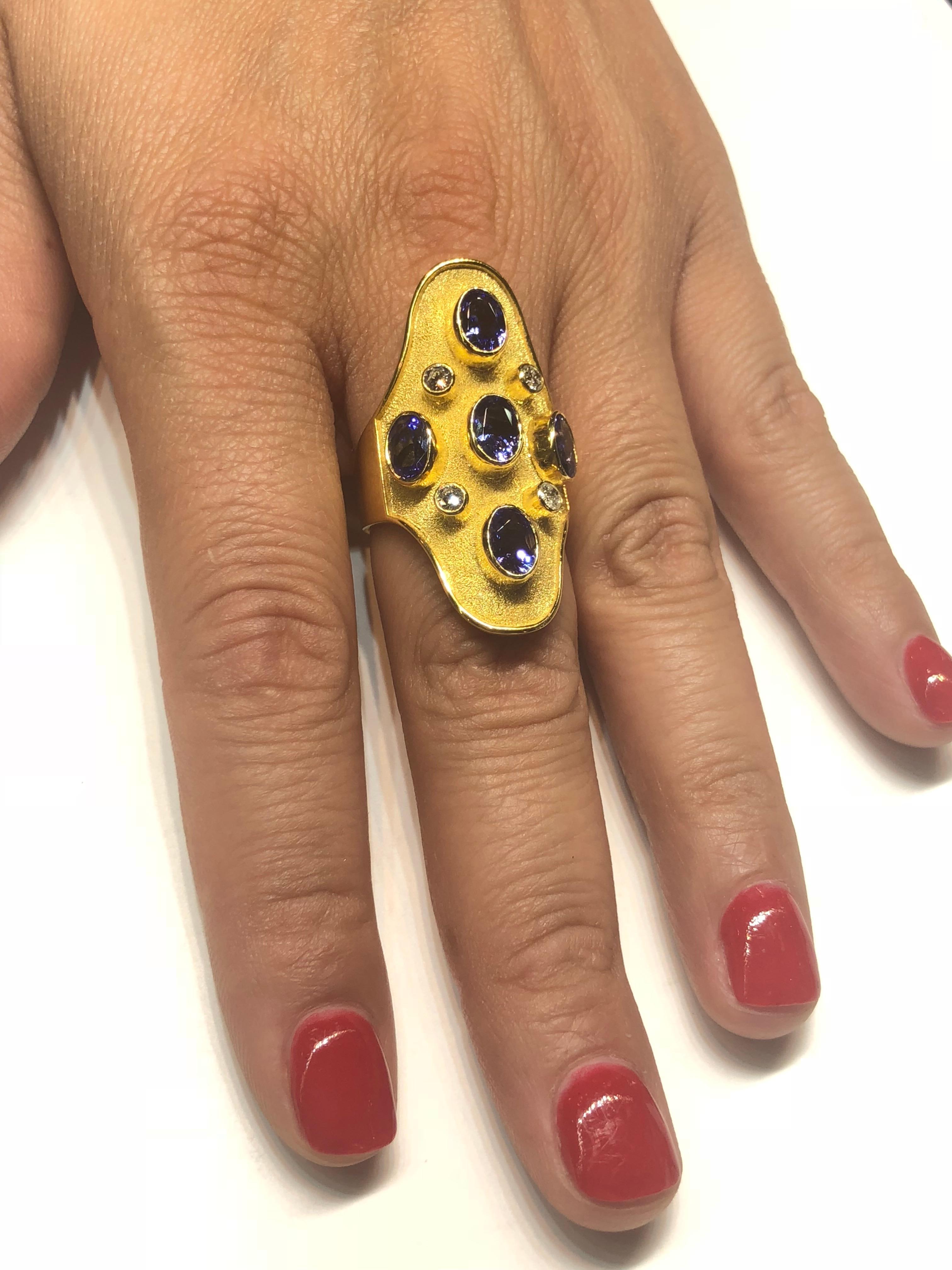 One of a kind S.Georgios designer Ring in solid Yellow Gold 18 Karat all handmade with the Byzantine granulation workmanship and unique microscopic velvet look on the background. This Ring is decorated with 5 oval natural Tanzanites total weight of